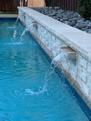 Geometric Pool with Raised Stone Waterfall Wall