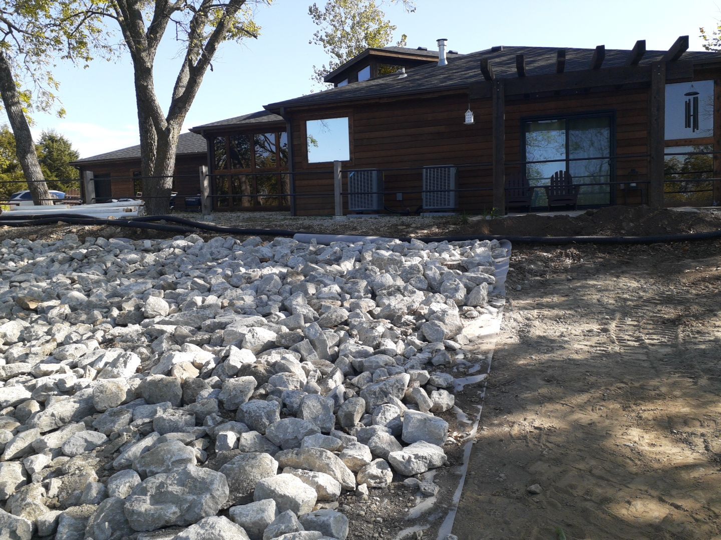 Supporting back of home with backfill at edge of steep creek by LAND ESCAPES LLC