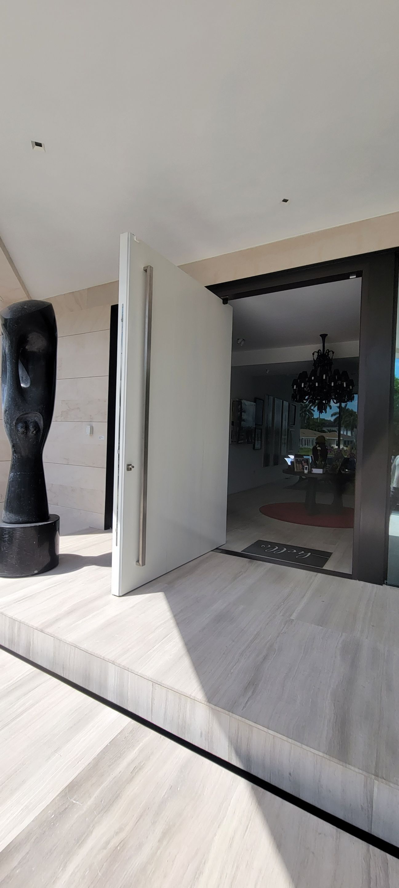 Custom Material Pivot Door installation by Impact Precious Wood Inc.