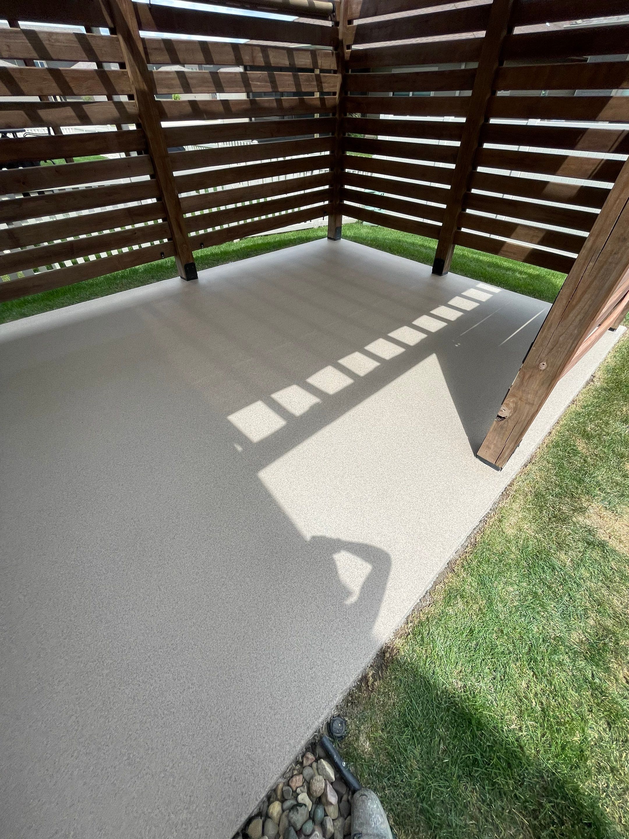 Textured Concrete Patio Coating and Custom Privacy Pergola in Sioux Falls by Select Painting, Coatings & Garage Cabinets