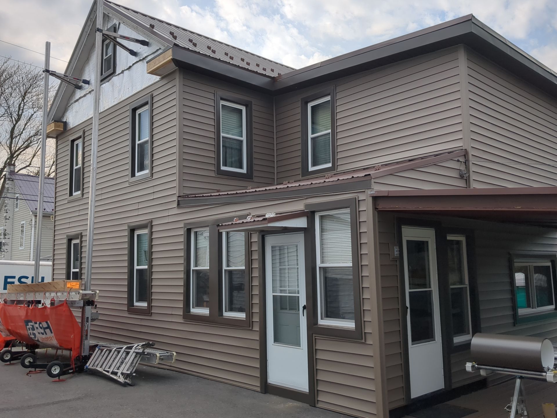 Exterior Renovation with Vinyl Siding, Metal Roof & Spouting  by Esh Builders