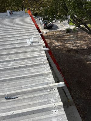 Metal roof panels with red ladder and truck