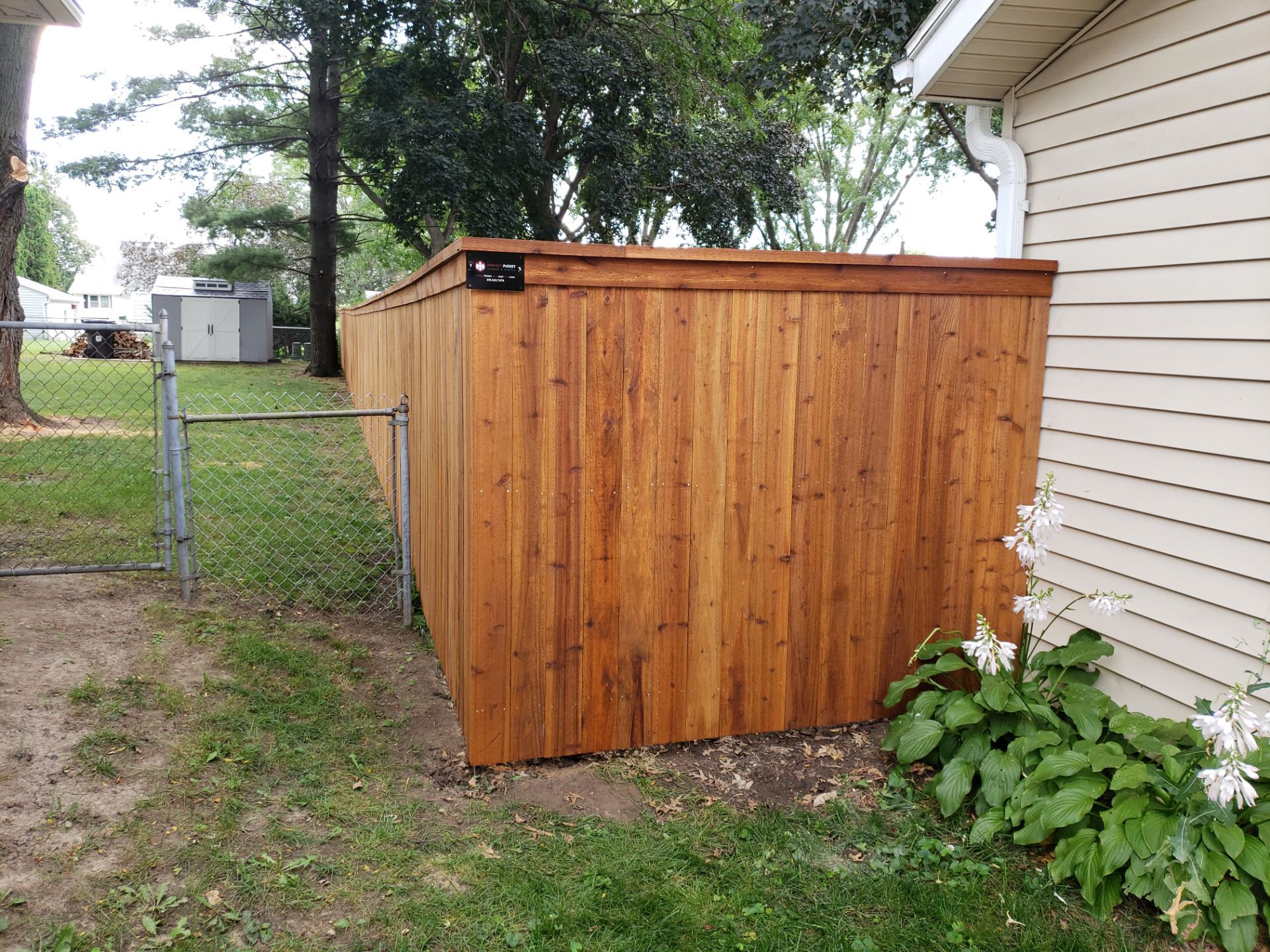 Custom Cedar Privacy Fence with Decorative Gate Windows in Cedar Falls by Perfect Picket Fence and Stain