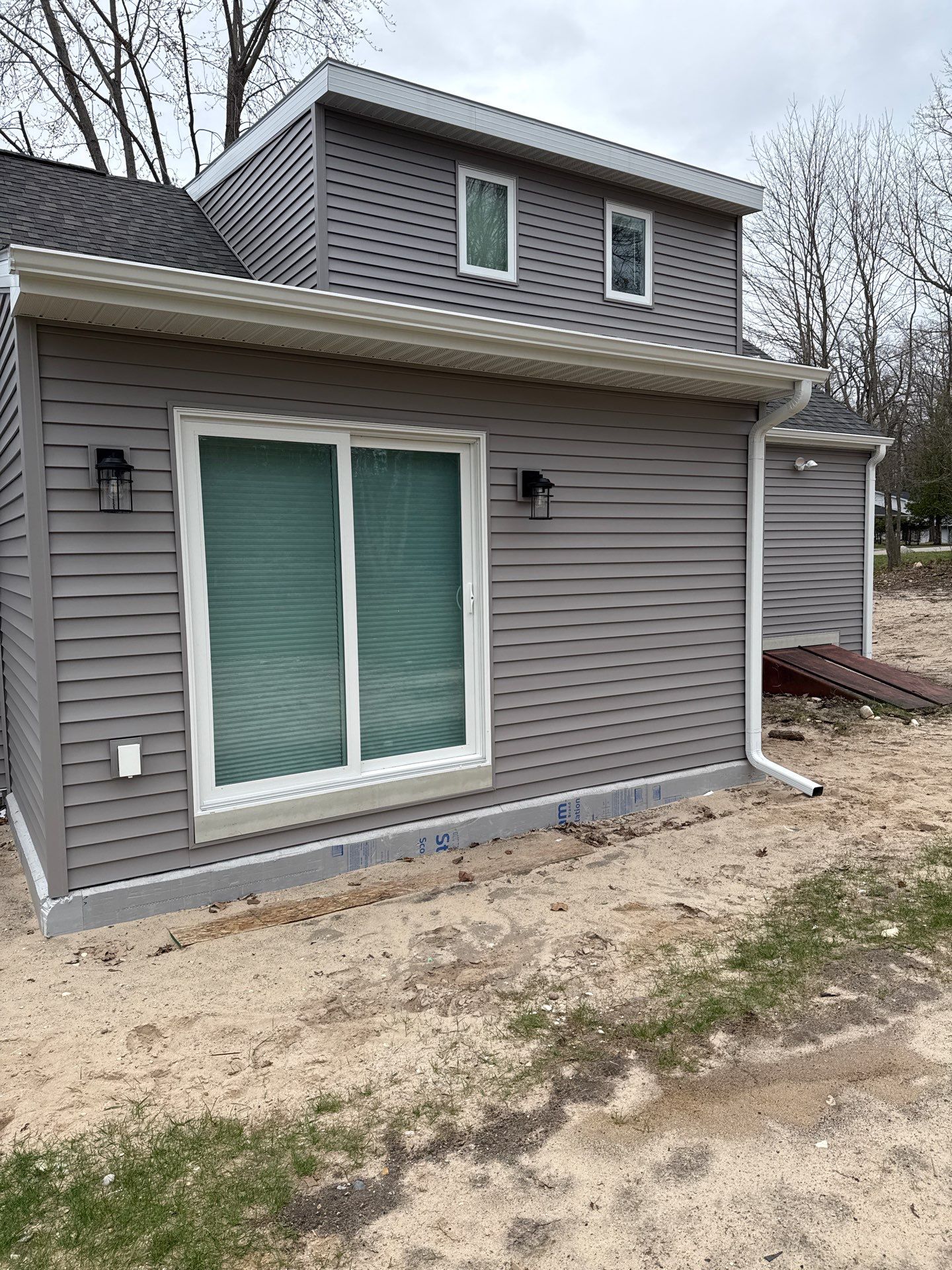 White Seamless Gutter and Downspout Installation in Charlevoix by Rainbow Seamless Systems