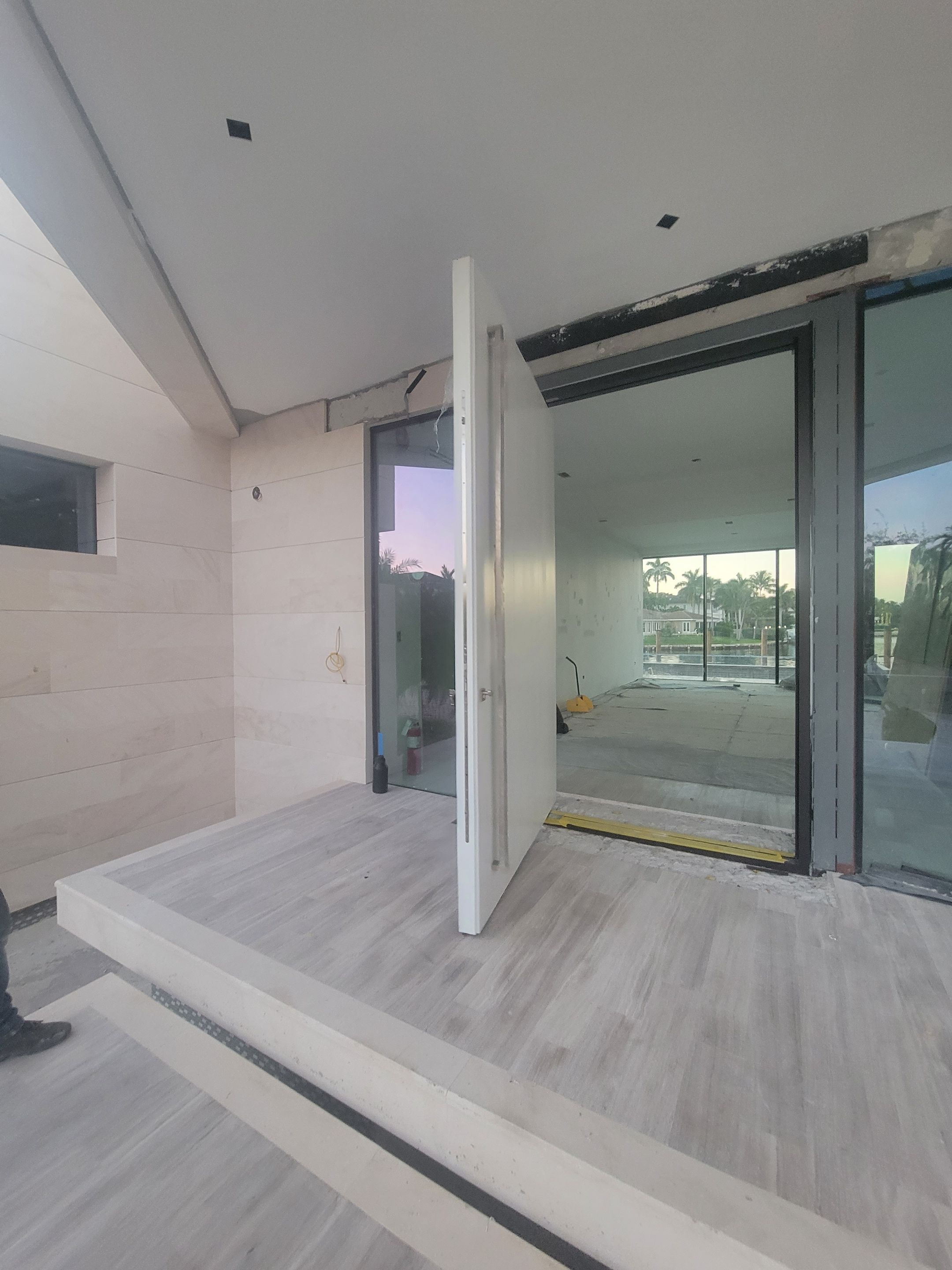 Custom Material Pivot Door installation by Impact Precious Wood Inc.