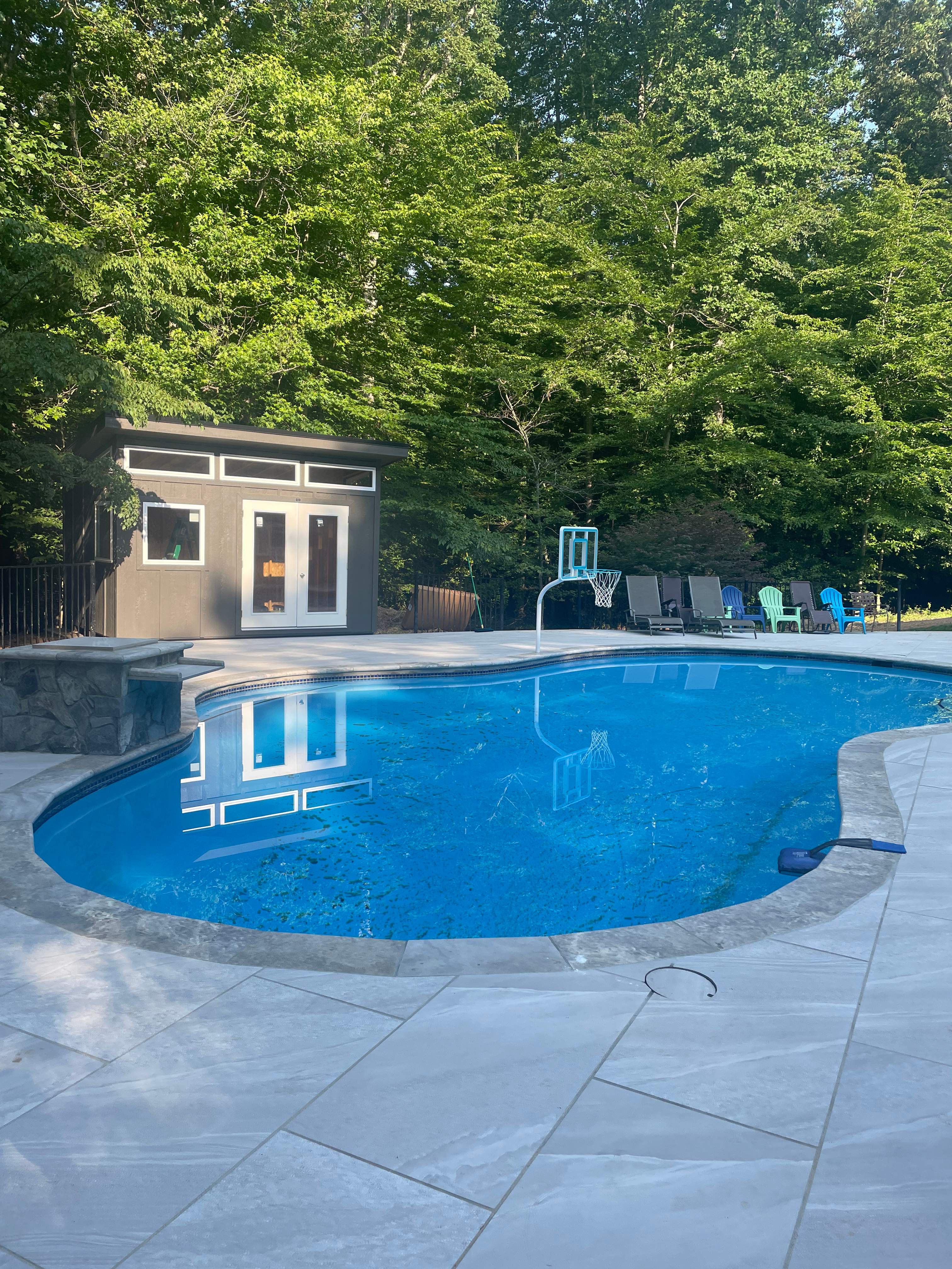 Pool Surround remodel with retaining walls, new waterfall and water slide by Fairfax Contractors, LLC