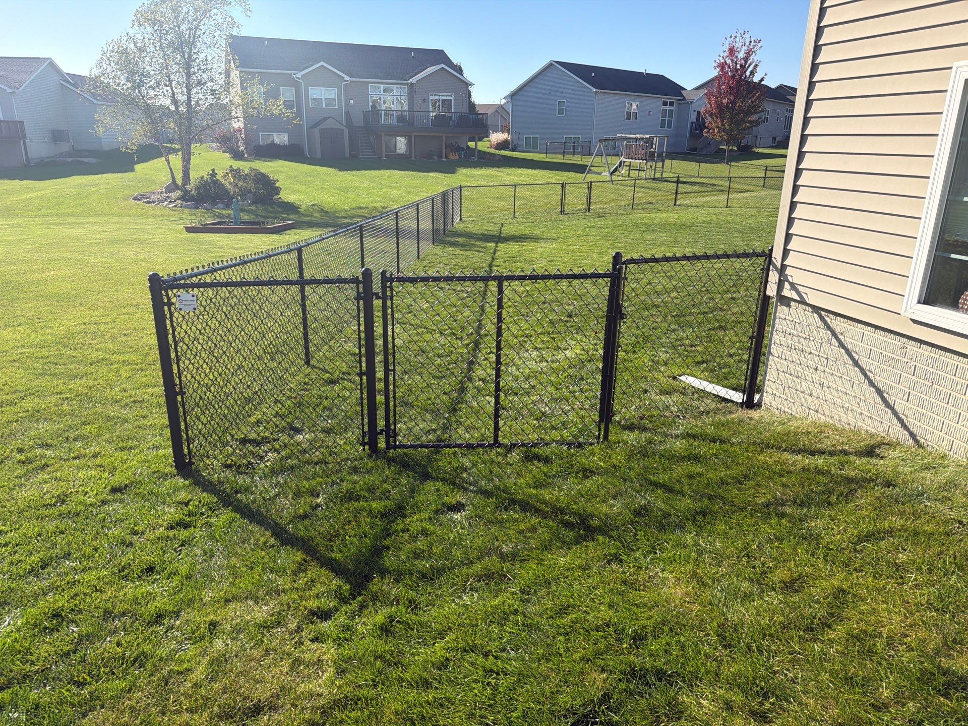 Black Vinyl-Coated Chain Link Fence Installation in Cedar Falls by Perfect Picket Fence and Stain