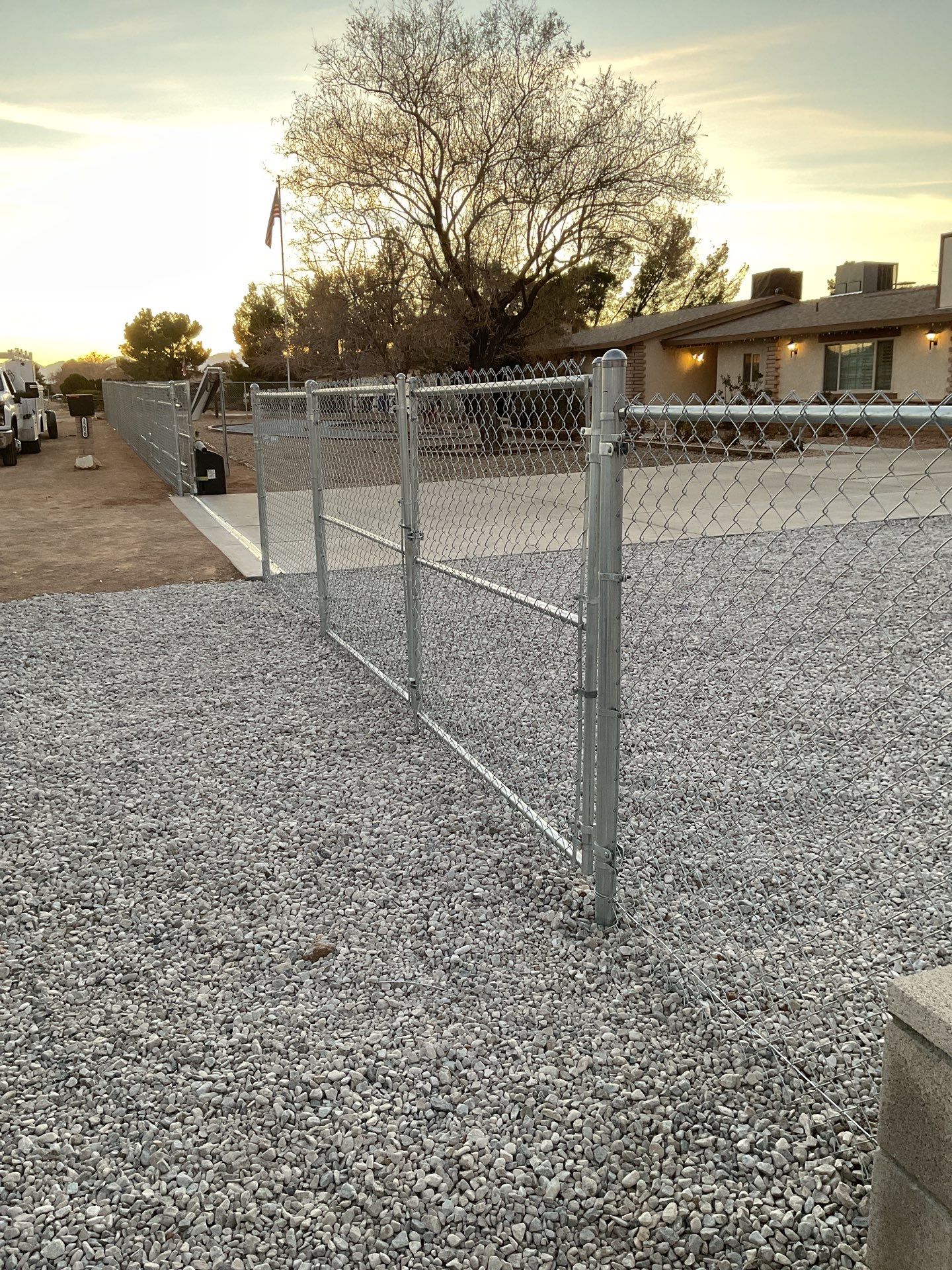 Sleek chain link fence installation with a solar motorized gate by Fence Guys Inc.