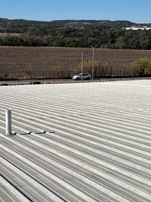 Metal roof surface with a single vent pipe.