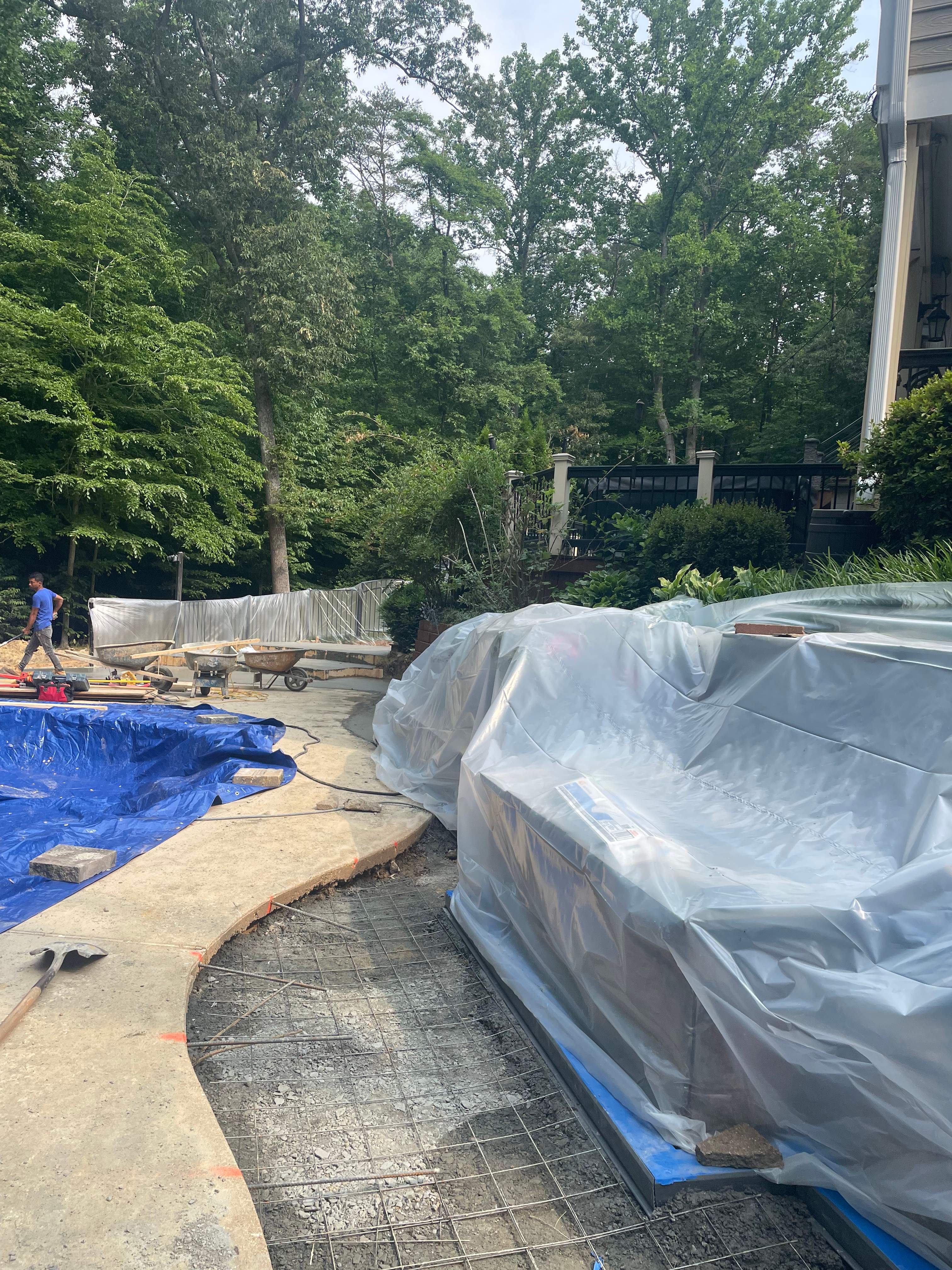 Pool Surround remodel with retaining walls, new waterfall and water slide by Fairfax Contractors, LLC