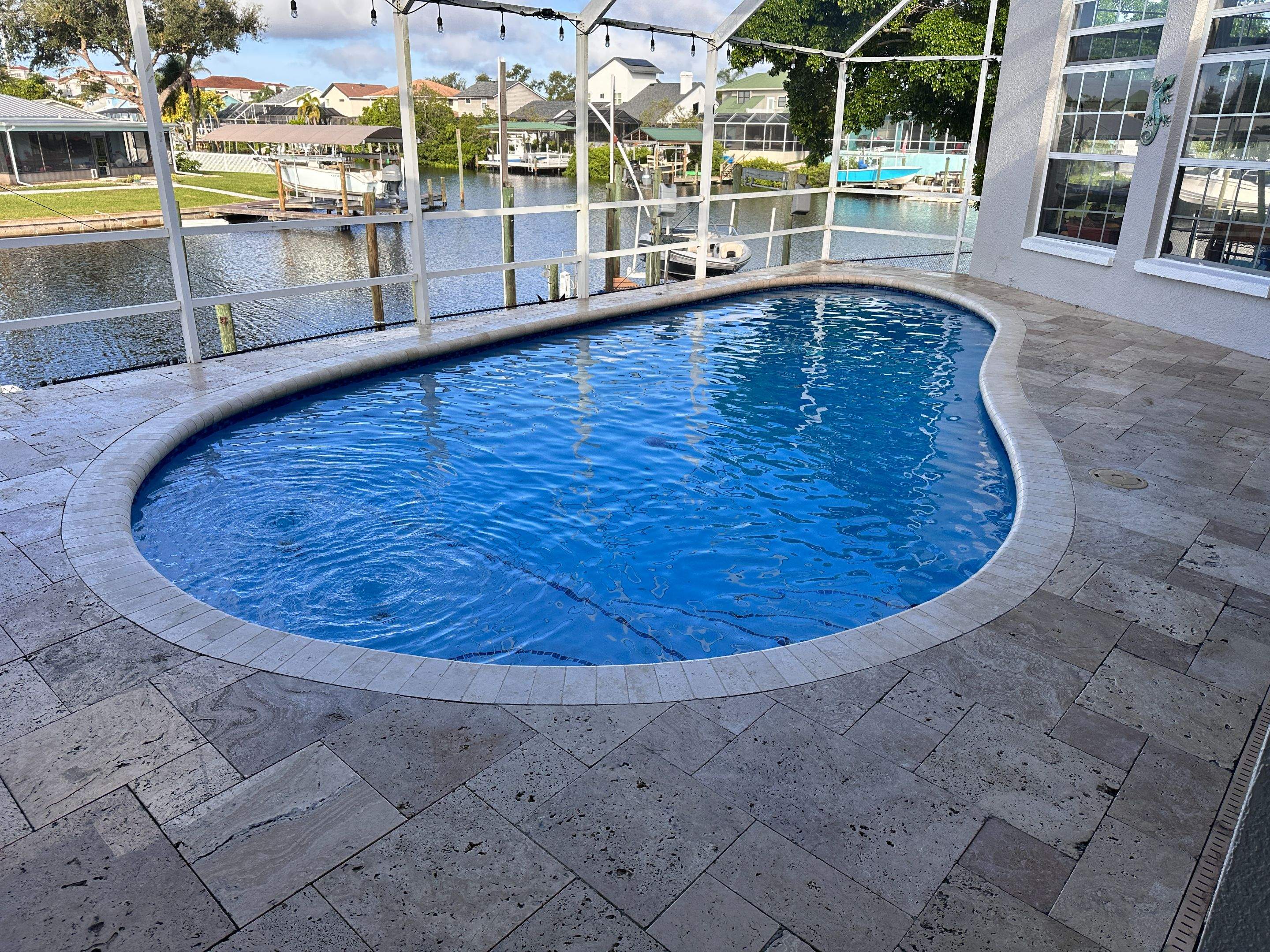Travertine Sealing and Stripping for a Waterfront Pool Deck in Apollo Beach by Supreme Paver Experts