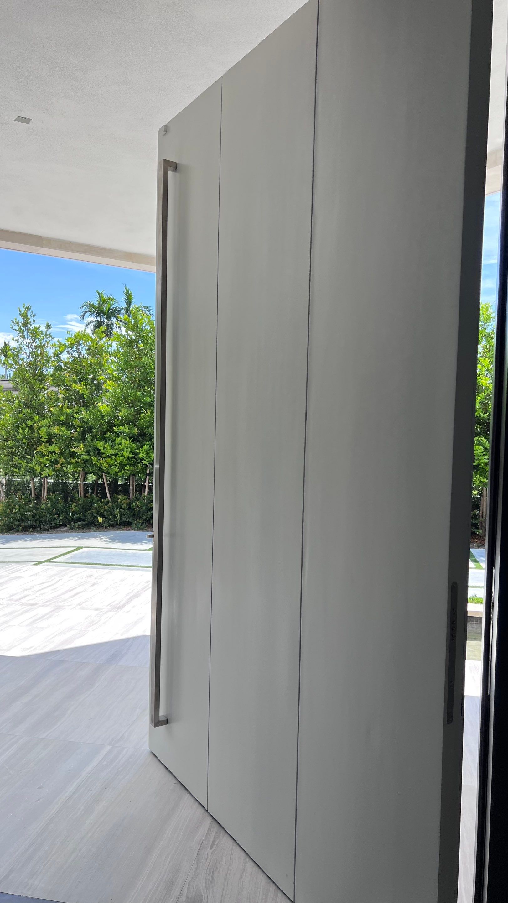 Custom Material Pivot Door installation by Impact Precious Wood Inc.