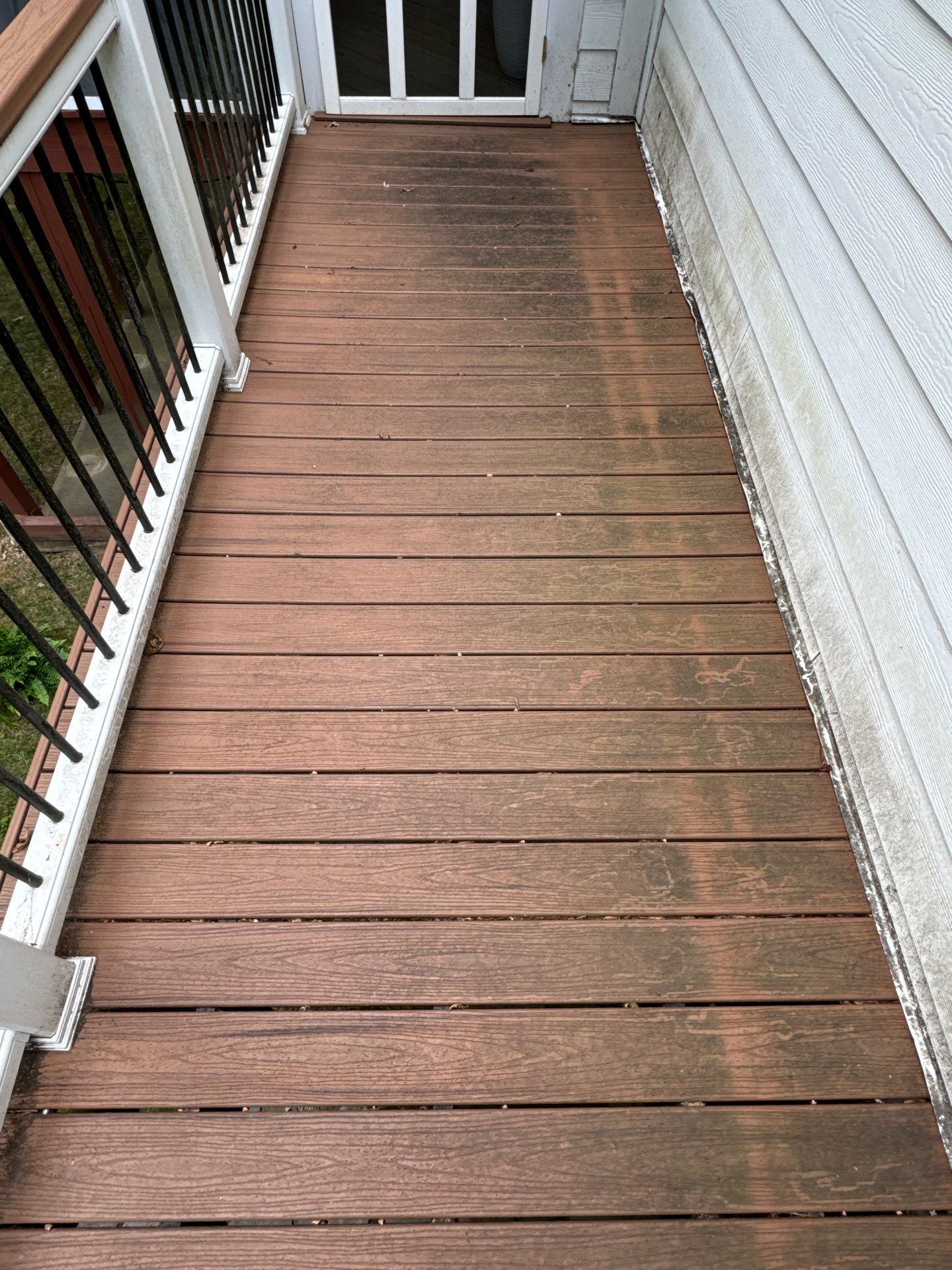 pressure washing company cleaning a wooden deck and adjacent siding exteriors in winston salem nc