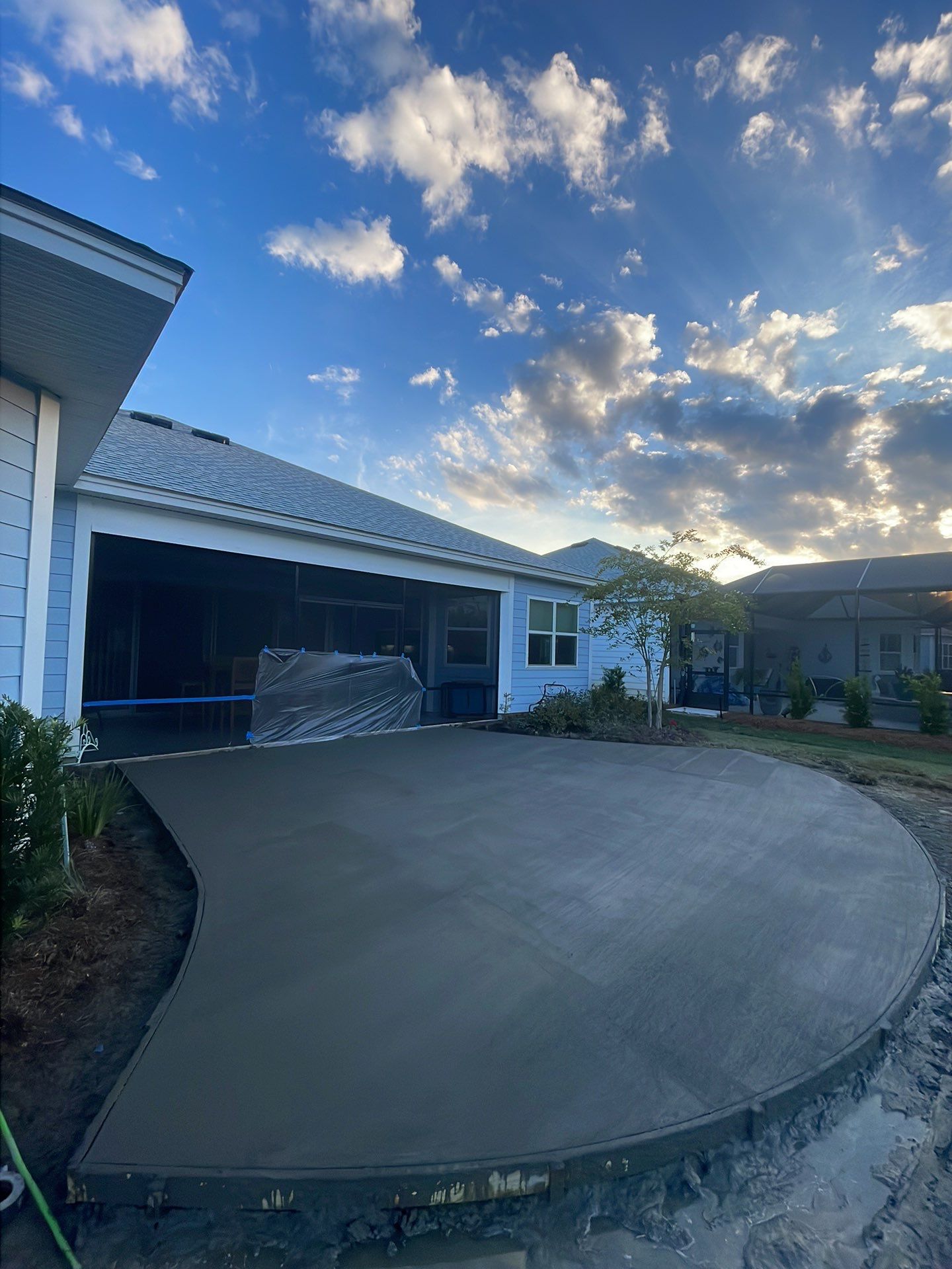 Custom Curved Concrete Patio and Paver Border in Hardeeville by Lowcountry Scapes, LLC