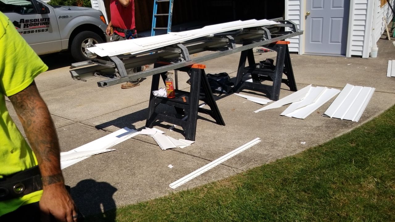 Siding Installation using Norandex woodsman dl-5 white woodgrain vinyl by Absolute Roofing and Construction