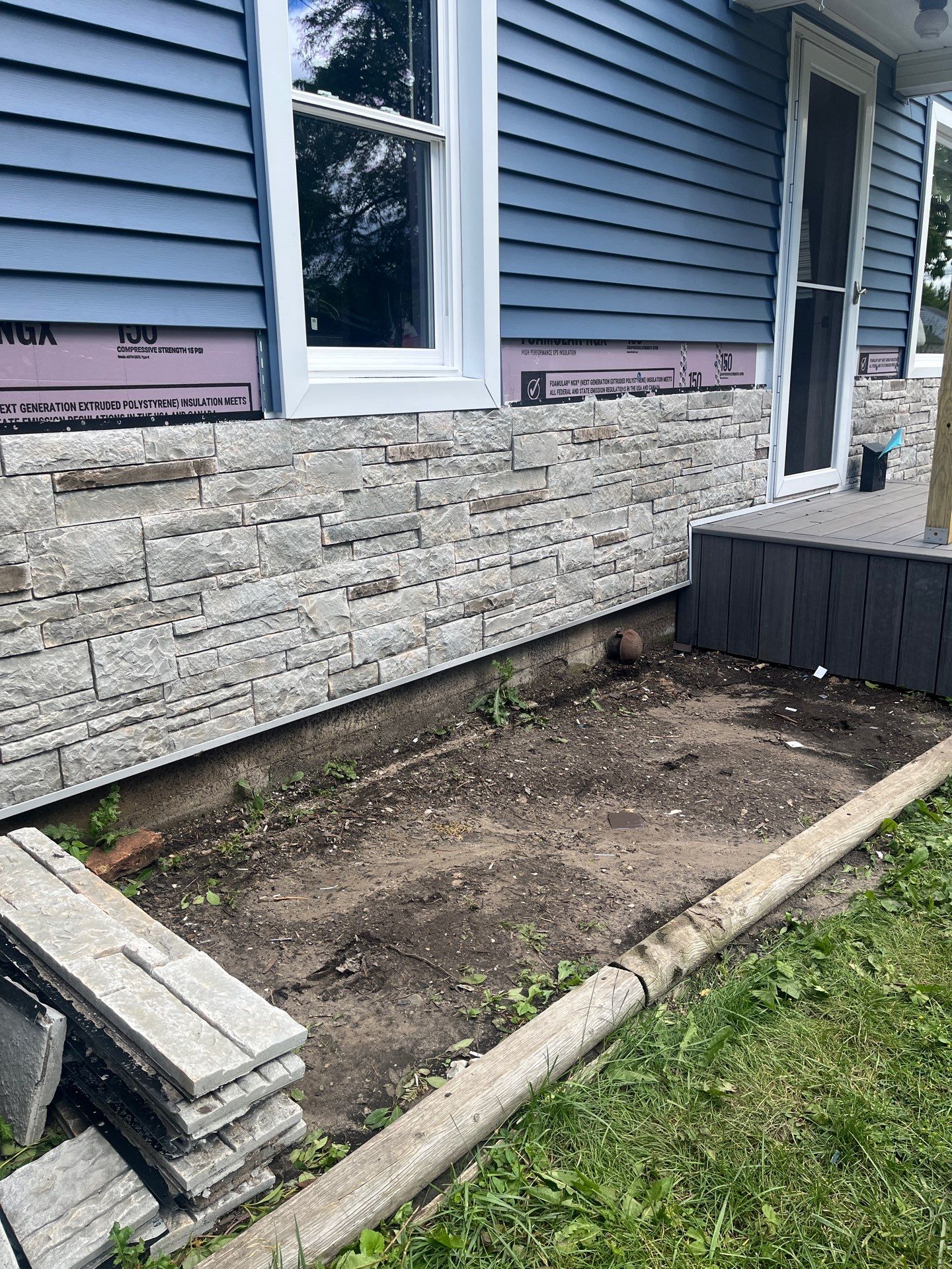 Blue Vinyl Siding and Versetta Stone Exterior Remodel in Bay City by Great Lakes Home Design LLC