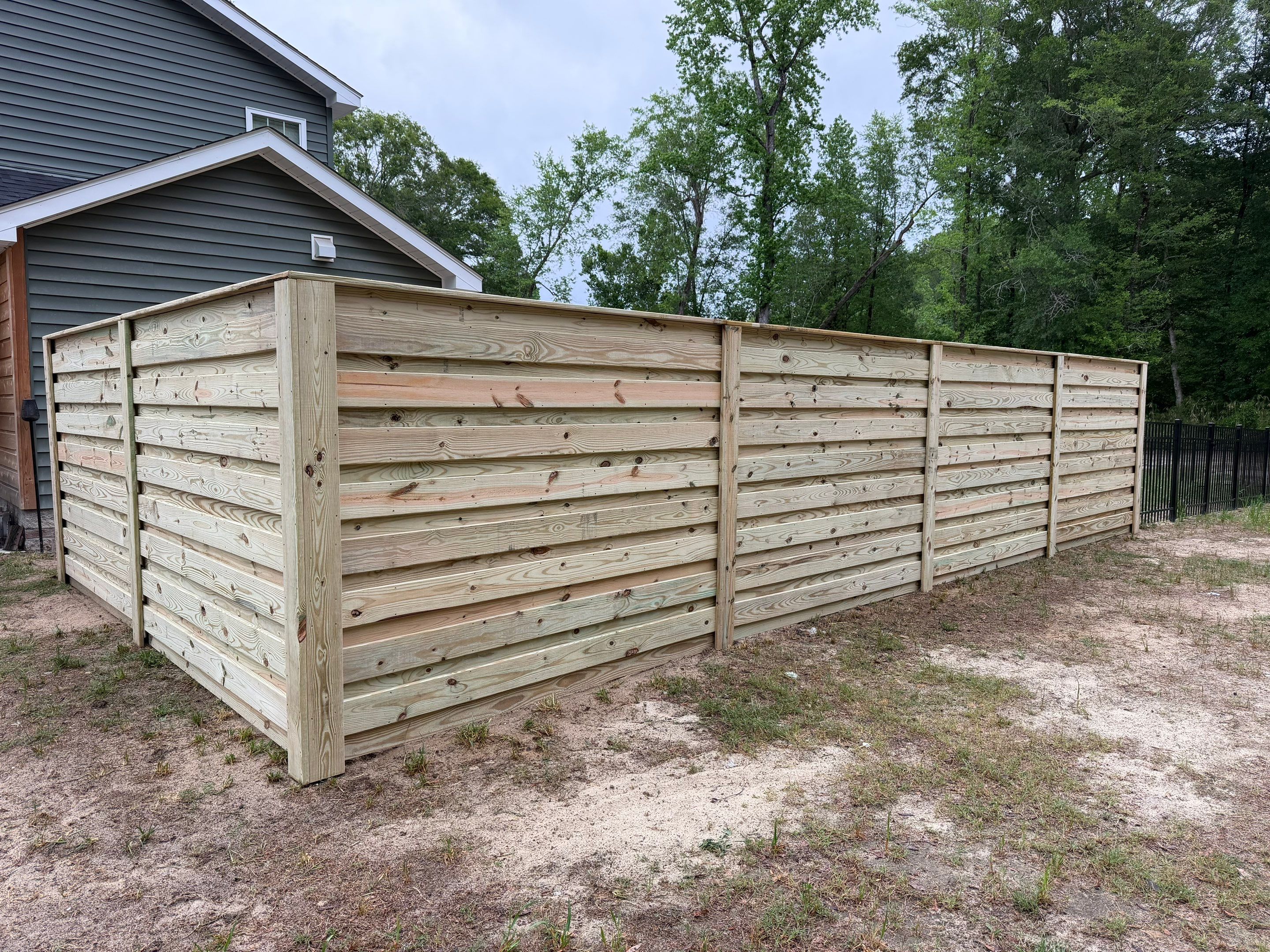 Modern Horizontal Wood Privacy Fence and Backyard Patio in Greenville by Superior Fence and Rail