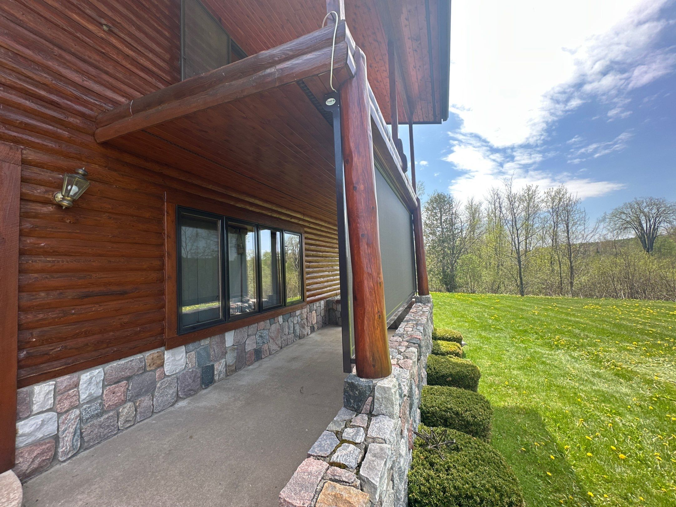 Sunesta Retractable Screen Installation on a Petoskey Log Home Porch by Rainbow Seamless Systems