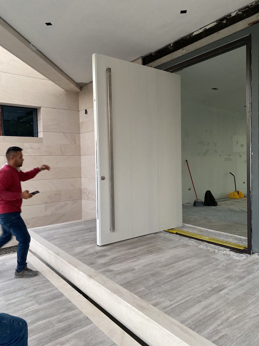 Custom Material Pivot Door installation by Impact Precious Wood Inc.
