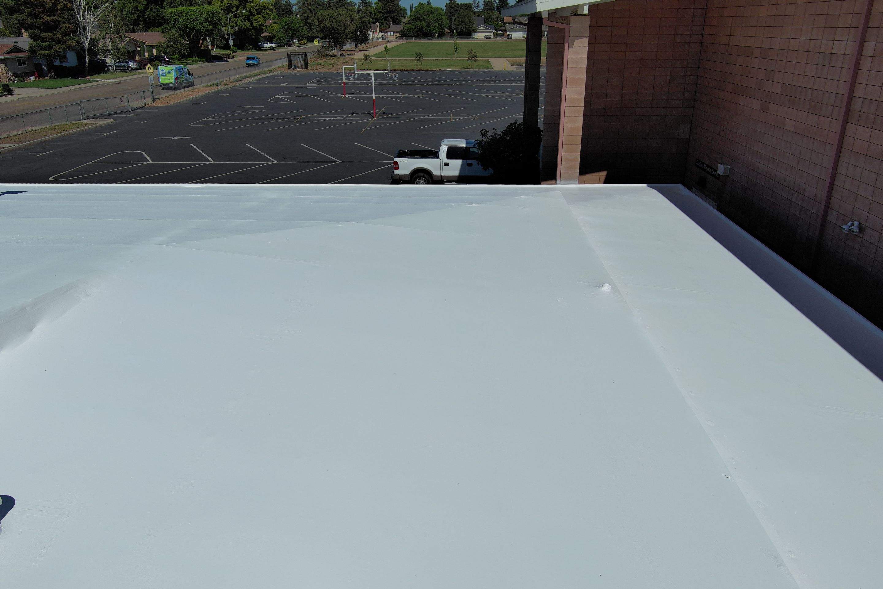 Single-ply restoration system using Benchmark/PUMA XL coatings over TPO single-ply roofing by Straight Edge Roofing Inc
