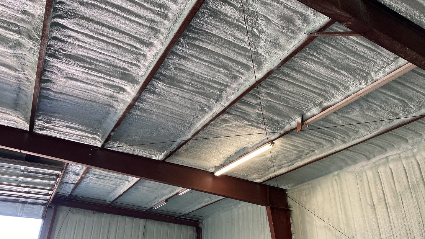 Spray foam insulation on inside of metal industrial building by Straight Edge Roofing Inc