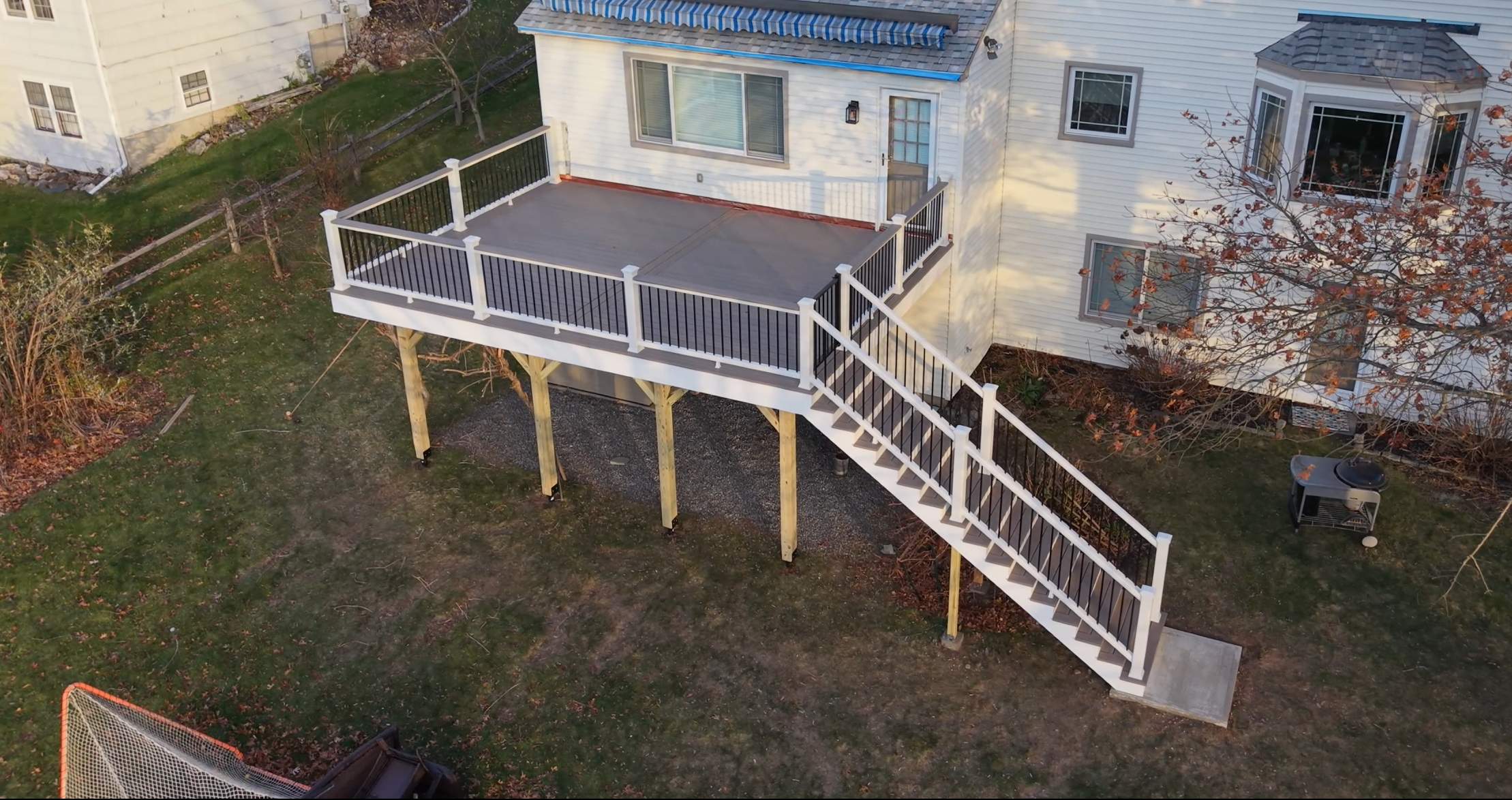 Replacement deck with Trex linage Biscayne boards and White Transcend railing with cocktail rail, and Trex gate. by DiGiorgi Roofing and Siding Inc