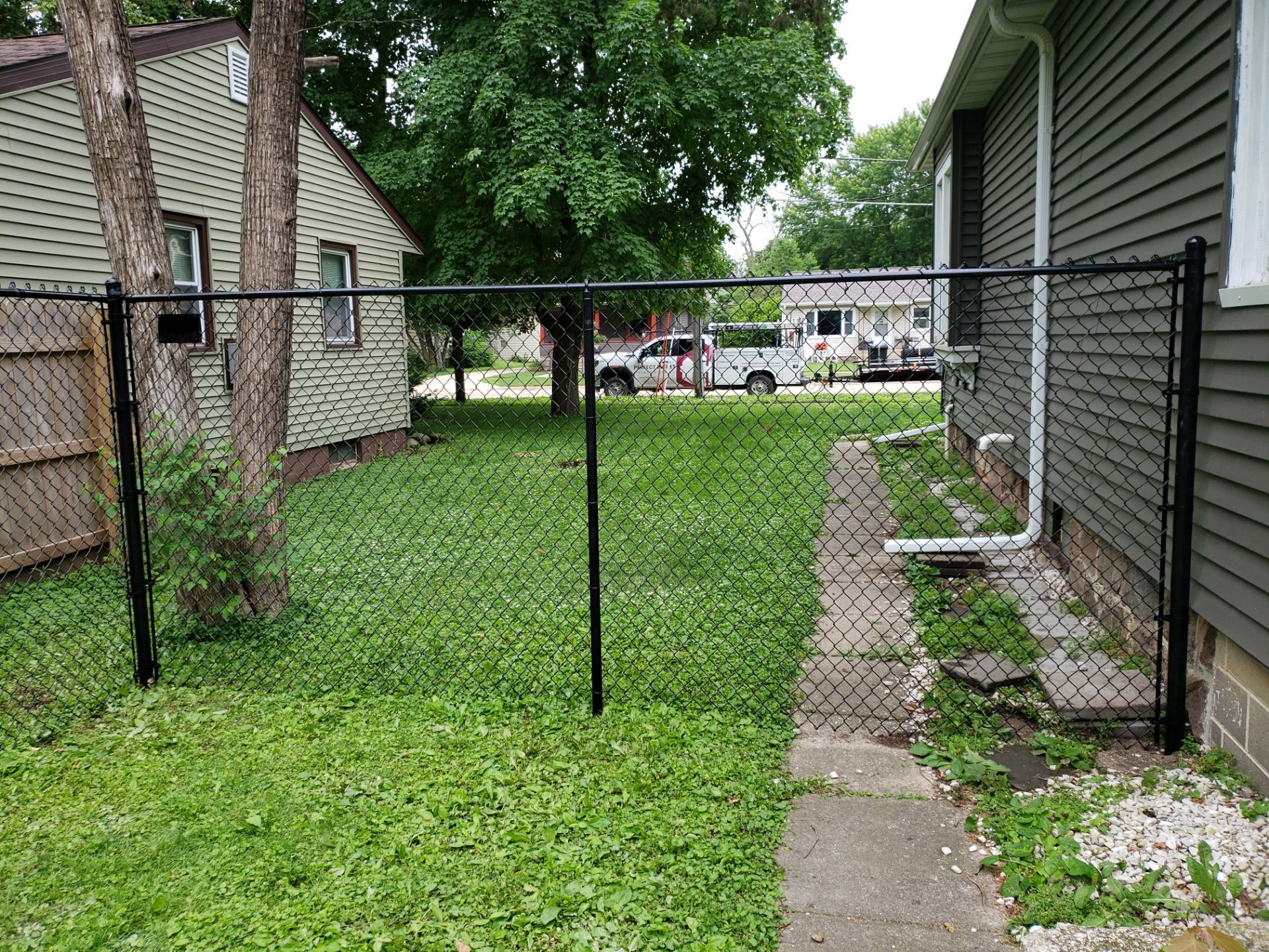 Black Vinyl Chain Link Fence Installation in Charles City by Perfect Picket Fence and Stain