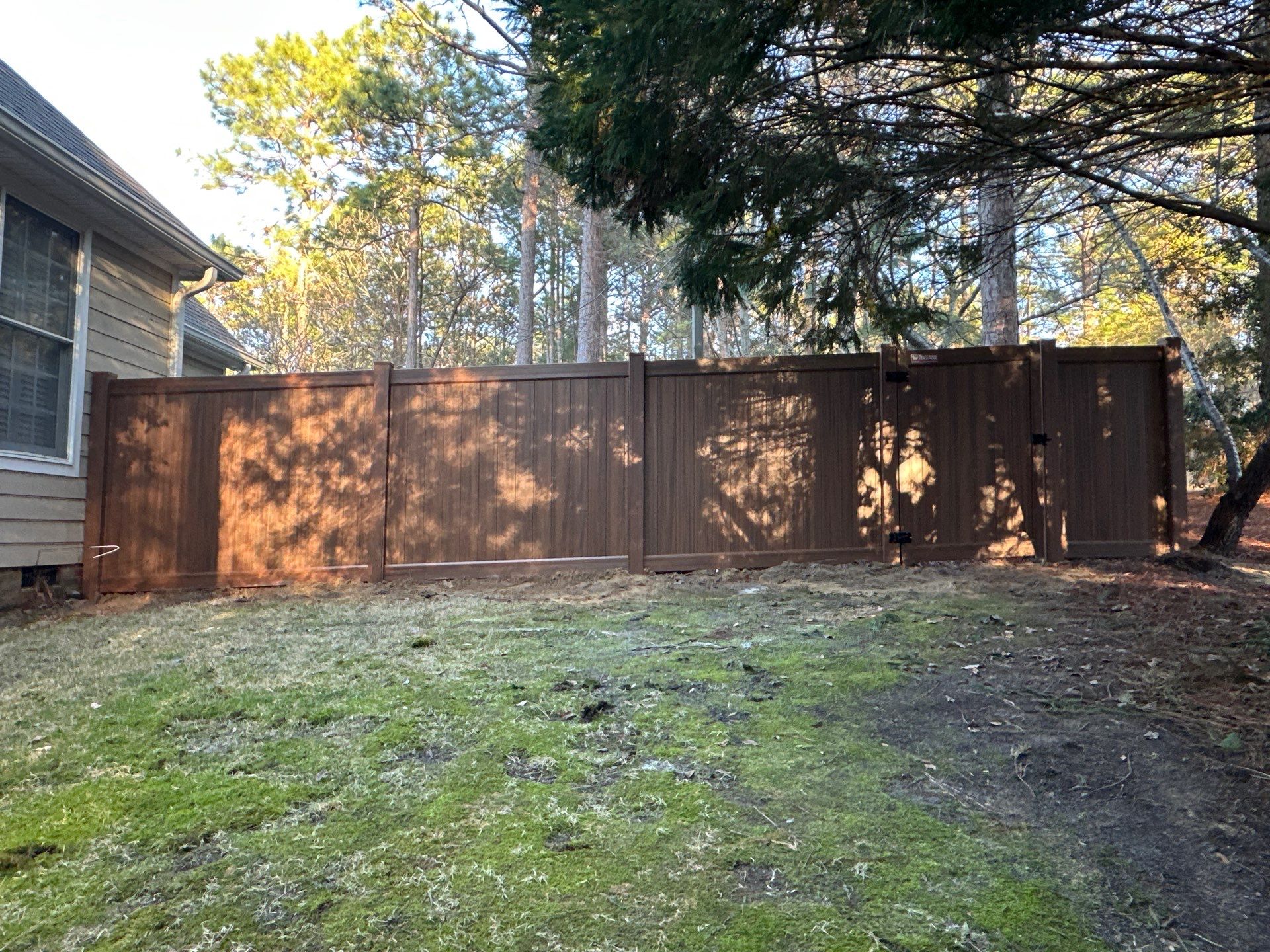 Mocha Walnut Wood-Grain Vinyl Privacy Fence Installation in Southern Pines by Superior Fence and Rail