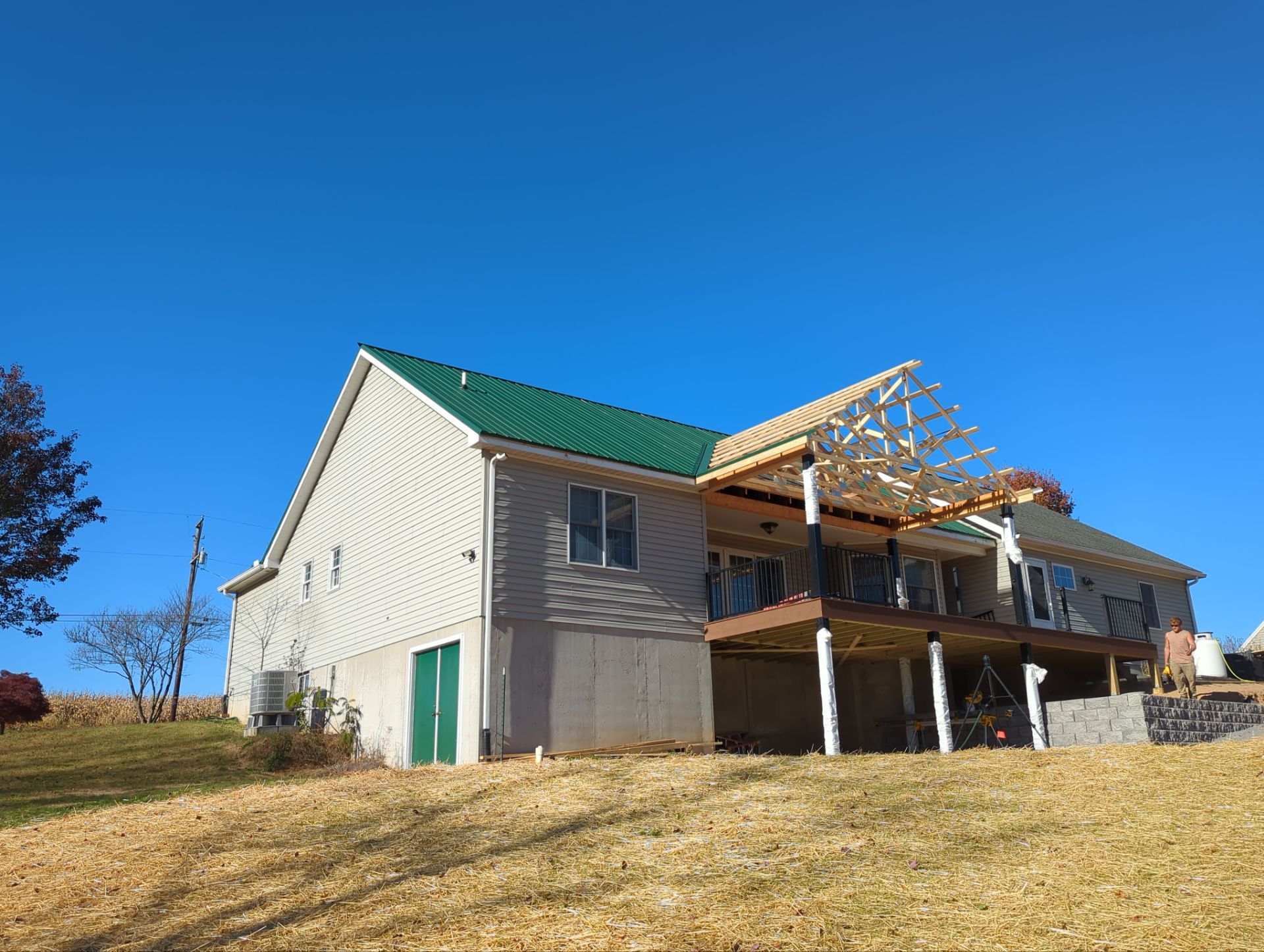 Green Metal Roof and Custom Covered Deck in Duncannon by Esh Builders