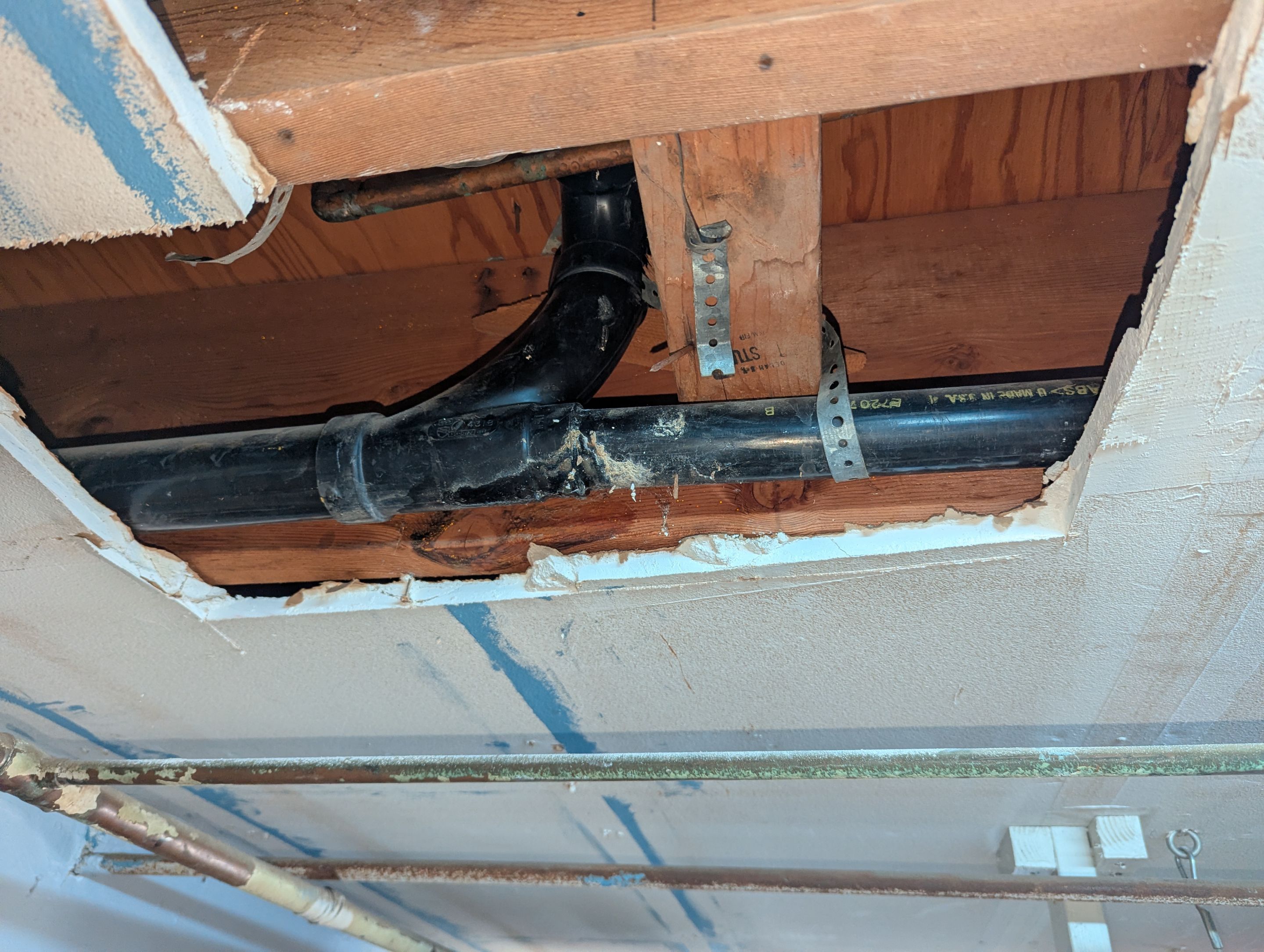 Drain line leak in garage ceiling by Professional Plumbing Inc 