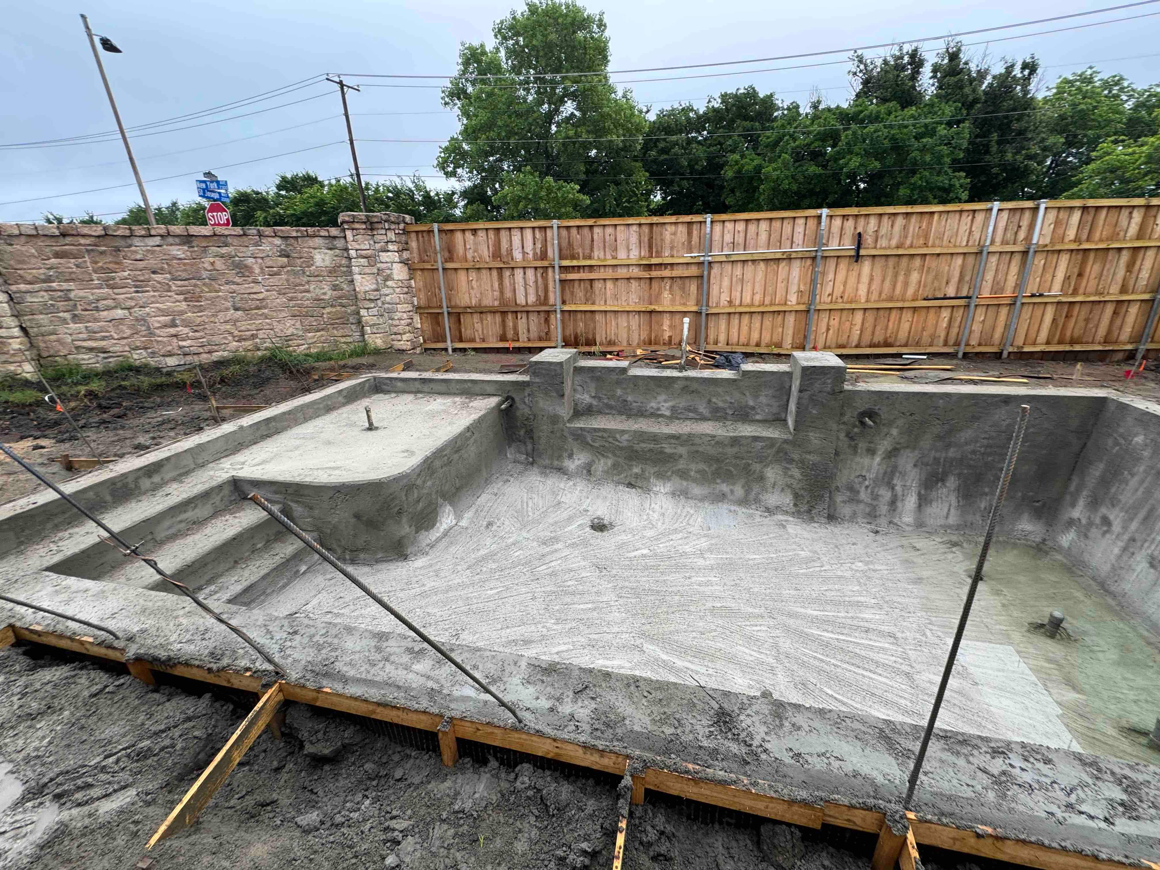 Geometric Pool with Raised Stone Accent Wall by Pinnacle Pools and Spas - DFW