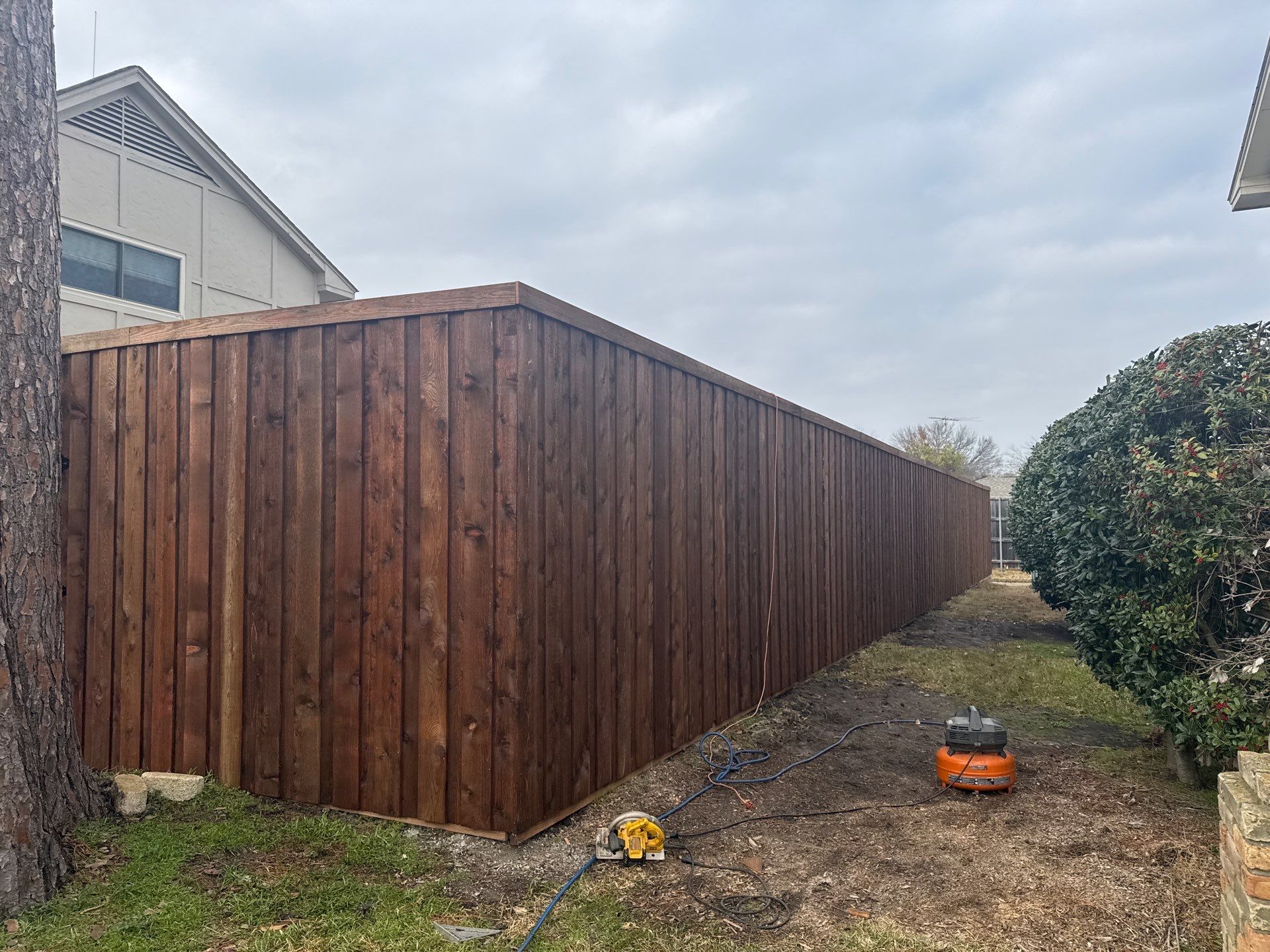 Pre-Stained board on board w/ trim and kickboard using 1x4 cedar trim by Grizzly Fence And Patio