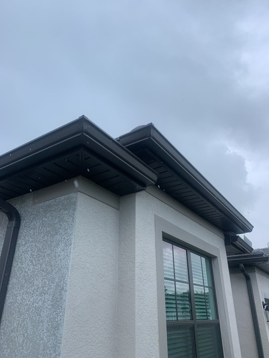 Seamless brown gutter and downspouts installation in Estero, FL  by Gutter Professors