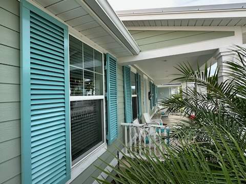 Hurricane Rated Colonial Shutters in Pastel Turquoise  by Smart Guard Shutters