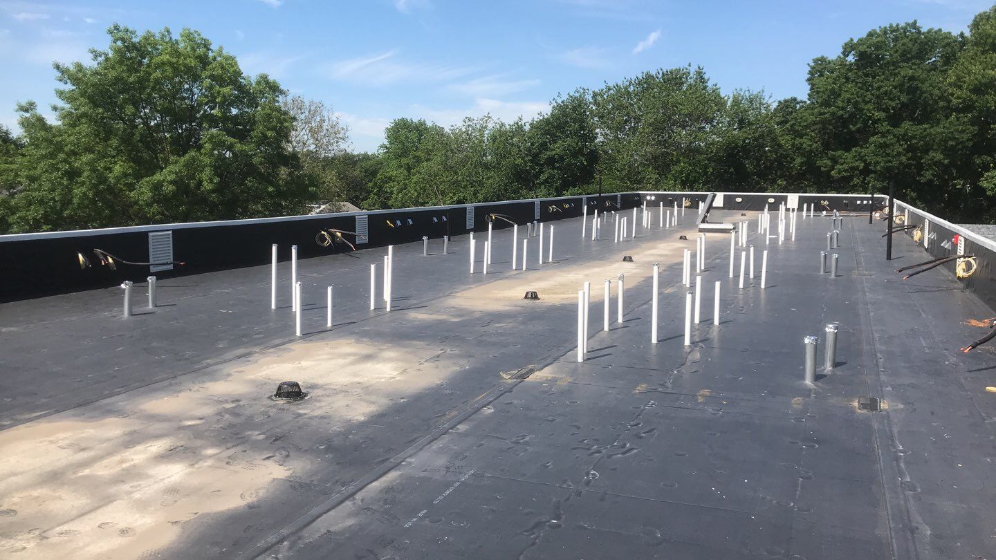 Commercial Roofing Installation using EPDM with white gutters by A Plus Exterior