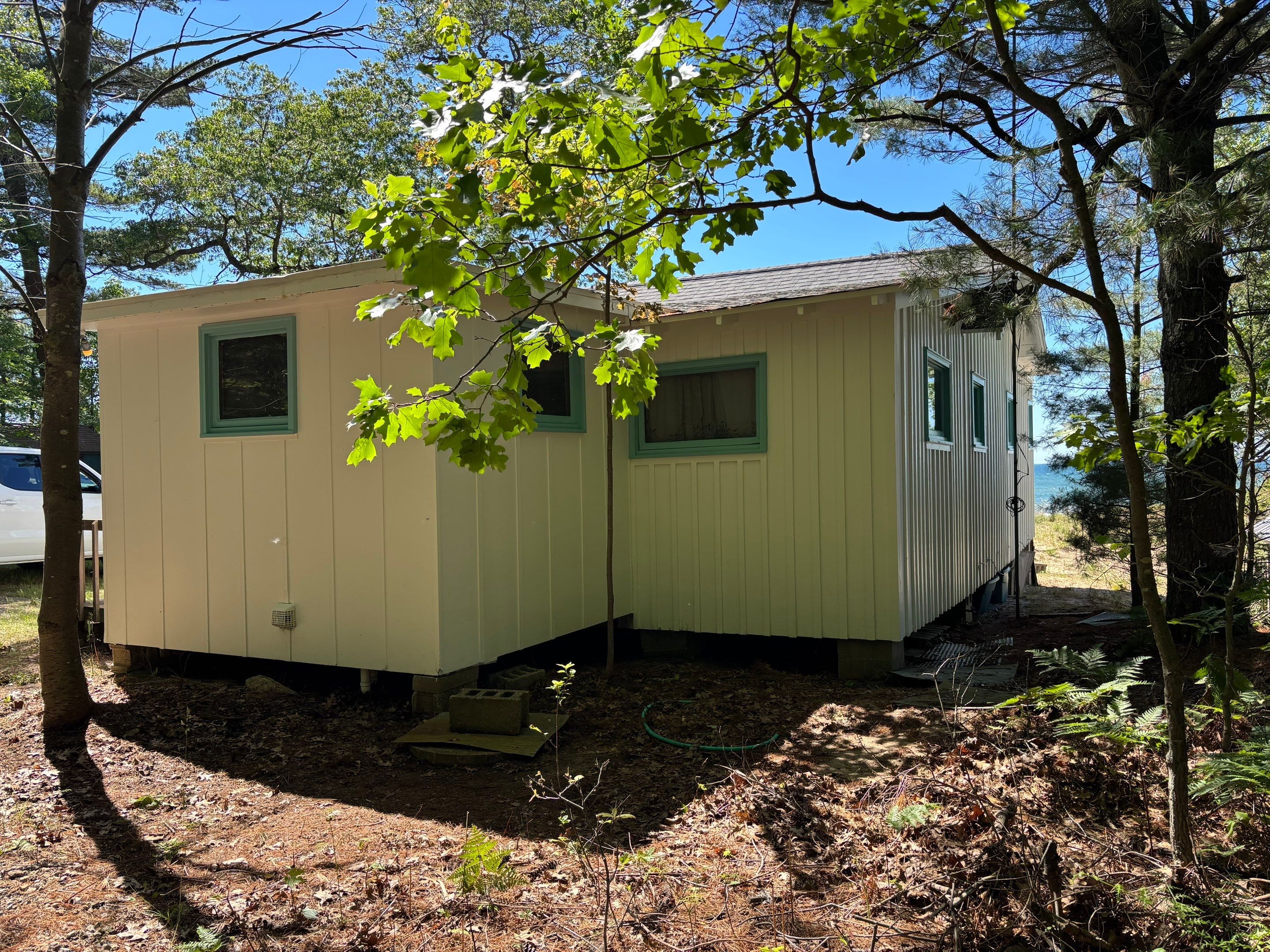 Lakeside Cottage Exterior Painting and Teal Trim Restoration in Mears by Gordon Painting