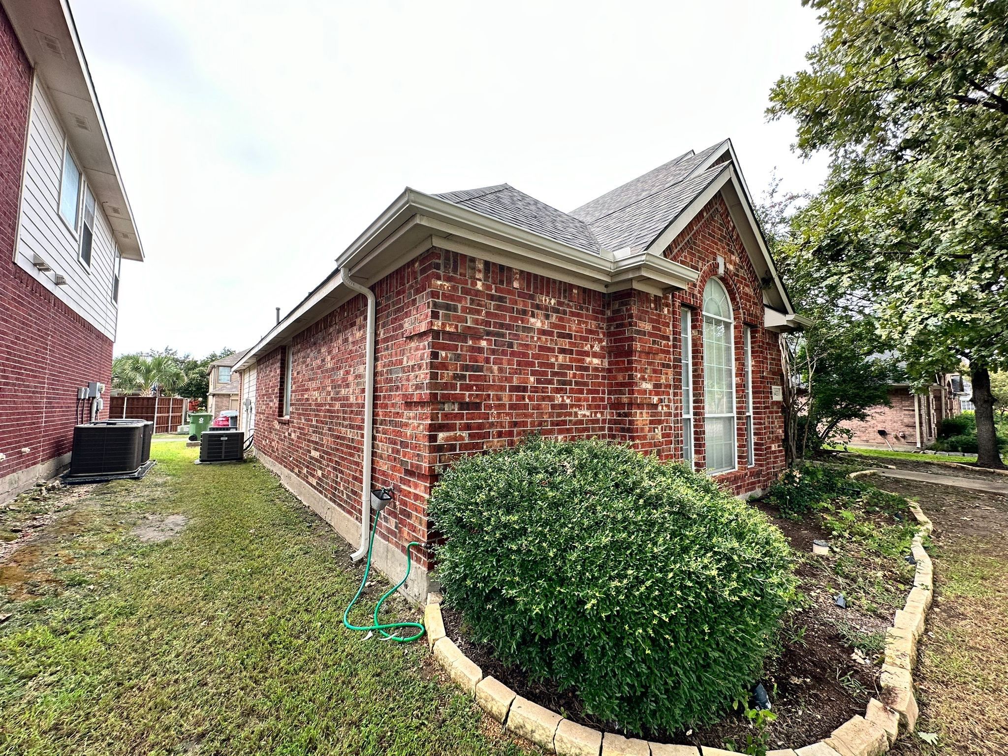 IKO Cornerstone-Dark Reddish Brown brick house  by Tejas Roofworks + Restoration