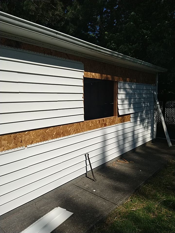 Siding Installation using Norandex woodsman dl-5 white woodgrain vinyl by Absolute Roofing and Construction