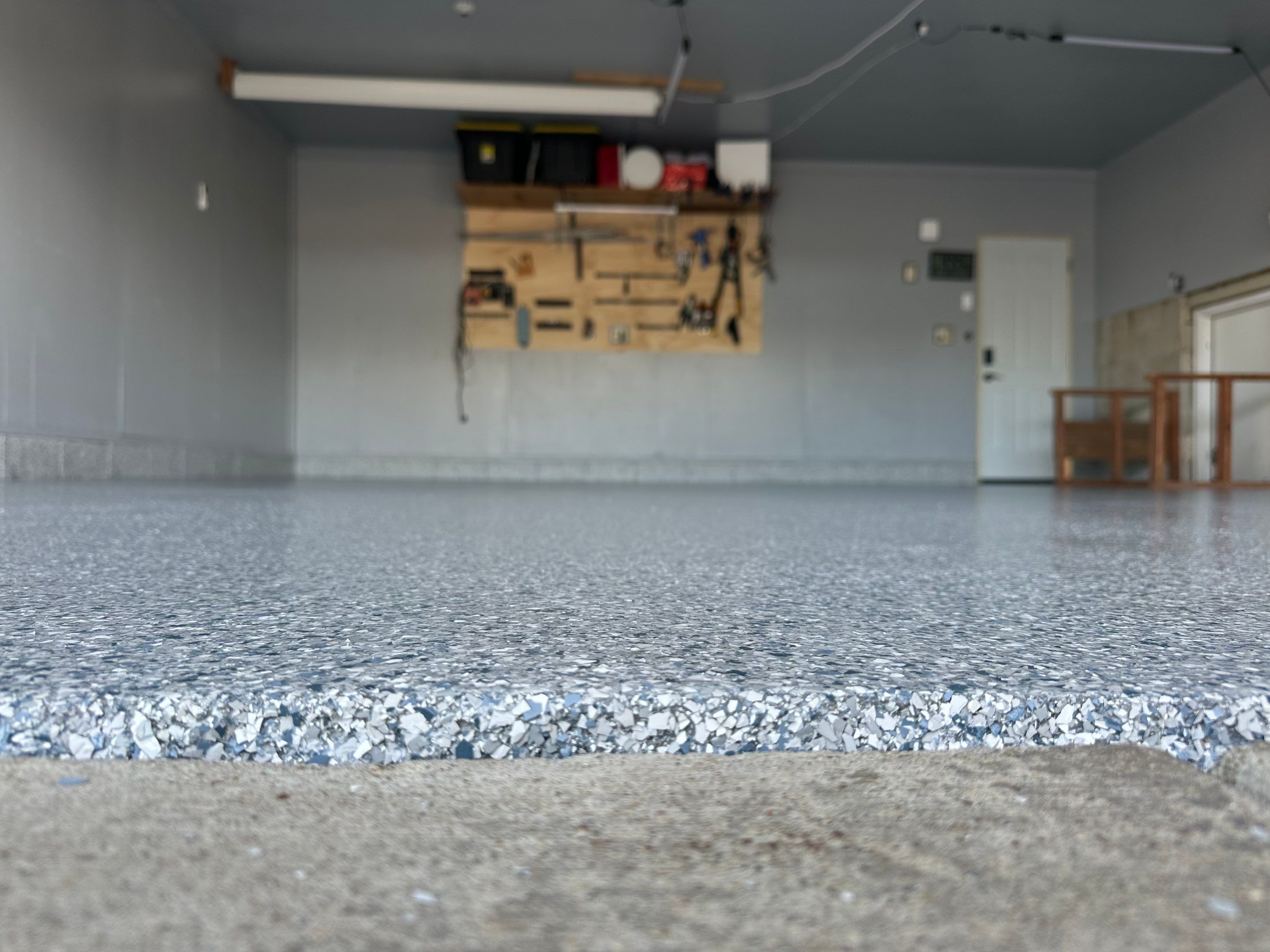 Multi-Colored Speckled Concrete Floor Coating Installation in Sioux Falls by Select Painting, Coatings & Garage Cabinets