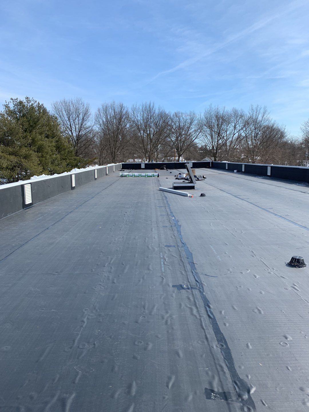 Commercial Roofing Installation using EPDM with white gutters by A Plus Exterior