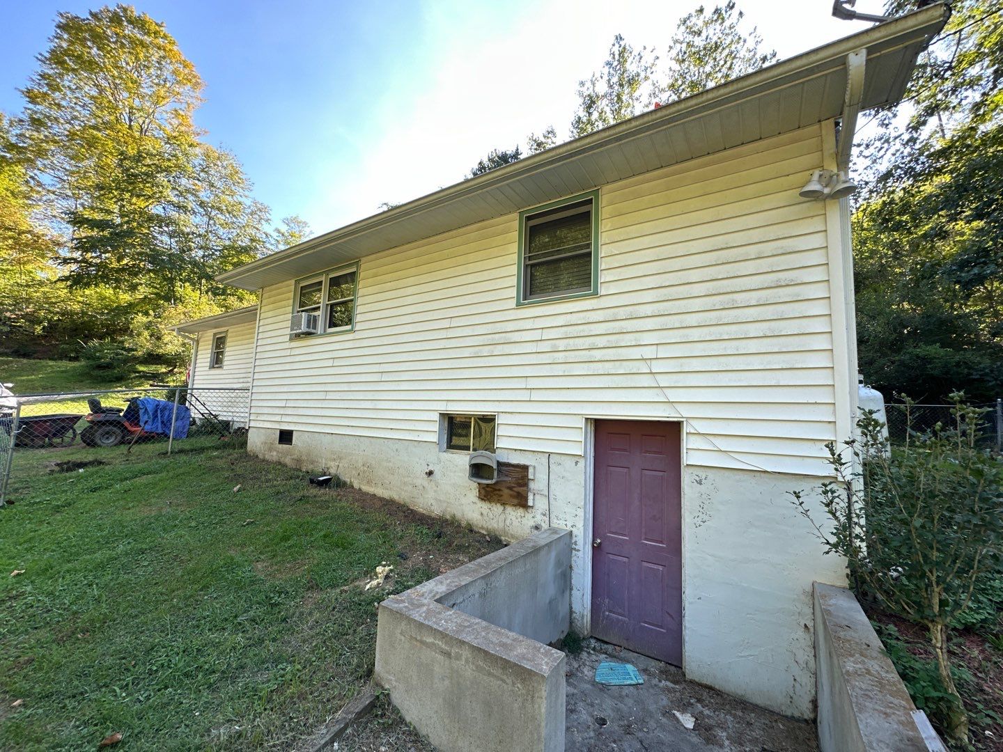 cleaning the exterior siding of a house and removing dirt and grime from the walls and foundation areas