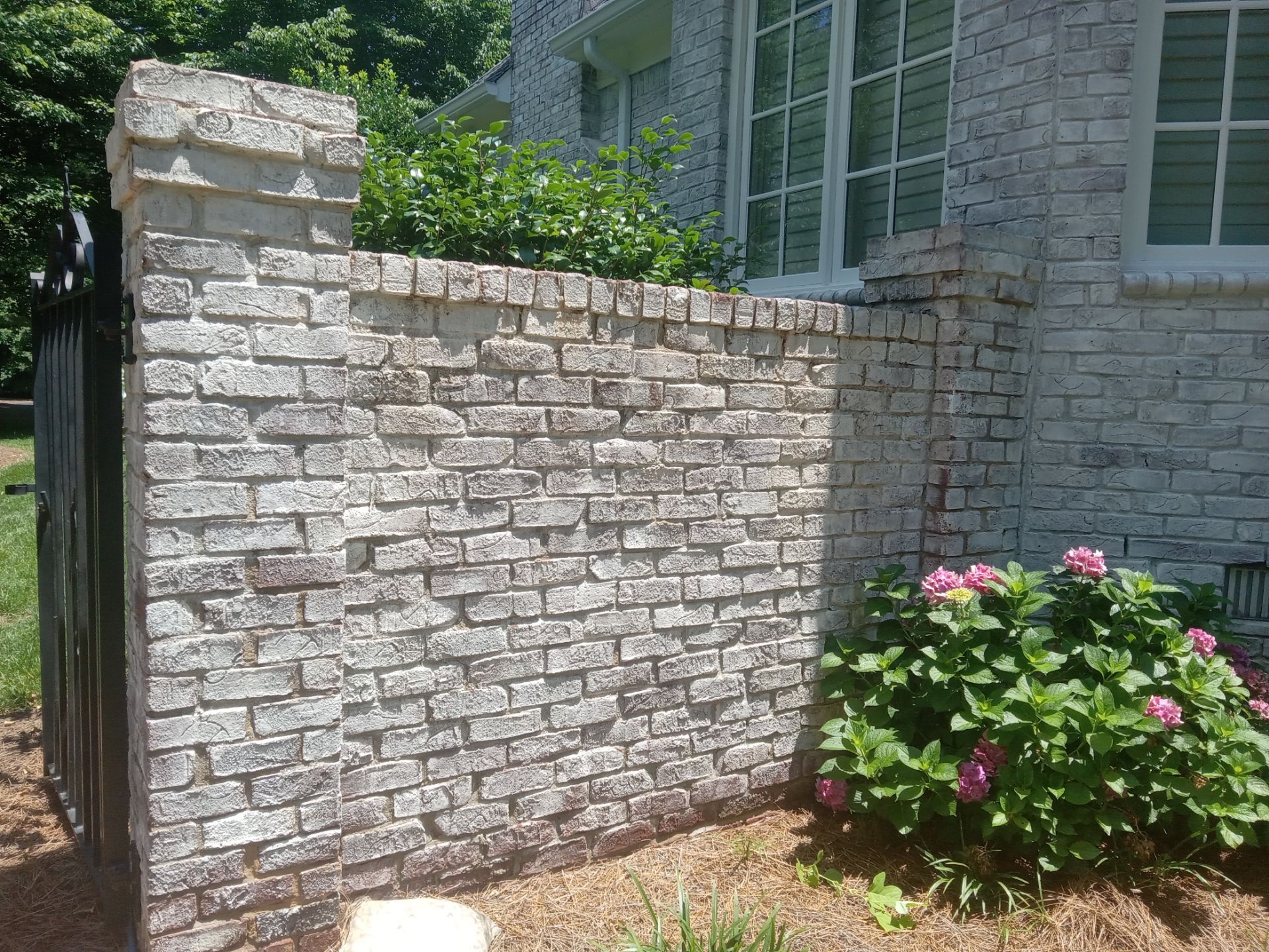 pressure washing stone wall and fence surfaces to remove dirt and discoloration restoring their appearance