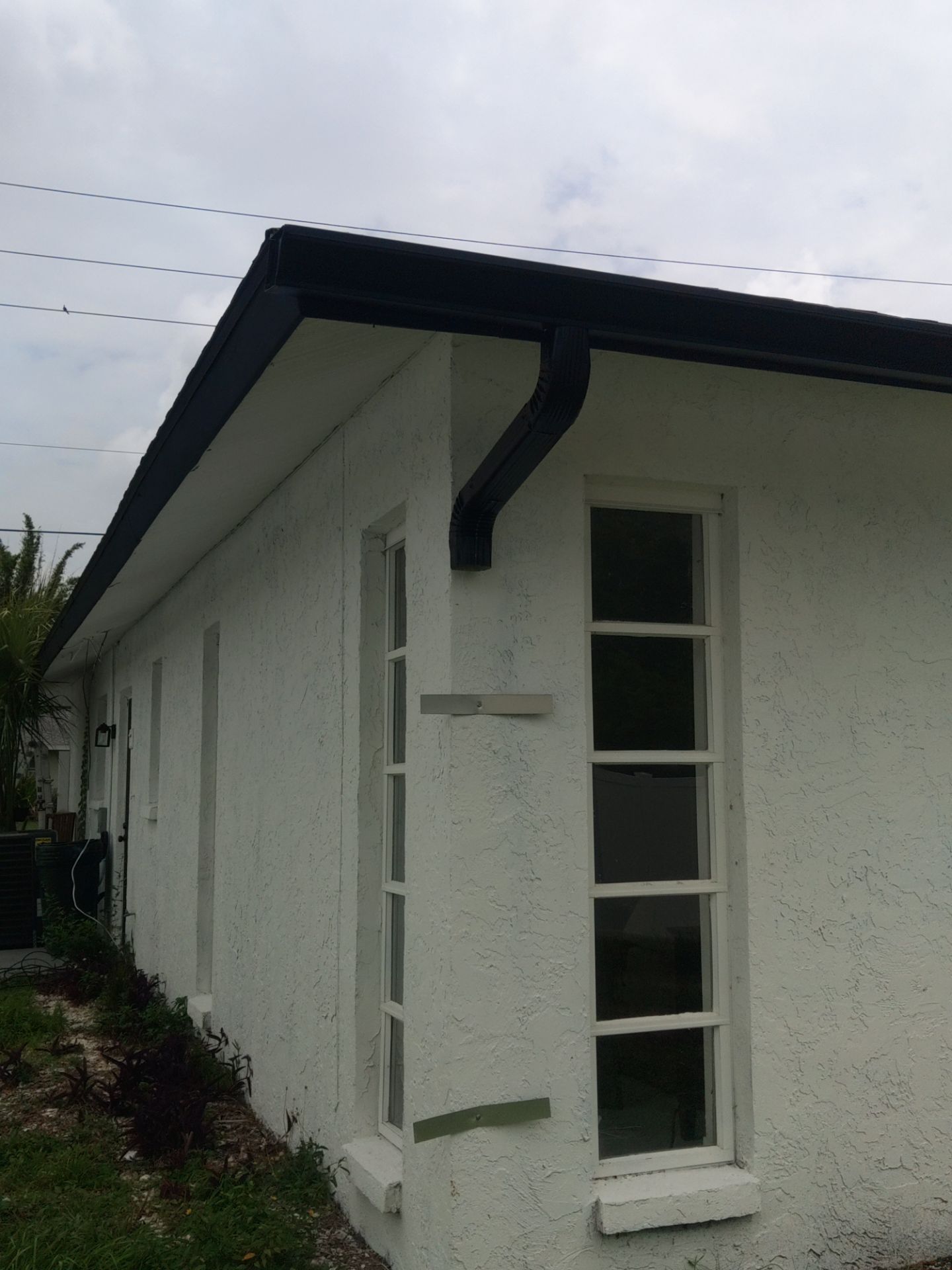 Black seamless gutters and downspouts installation in Sarasota, FL by Gutter Professors