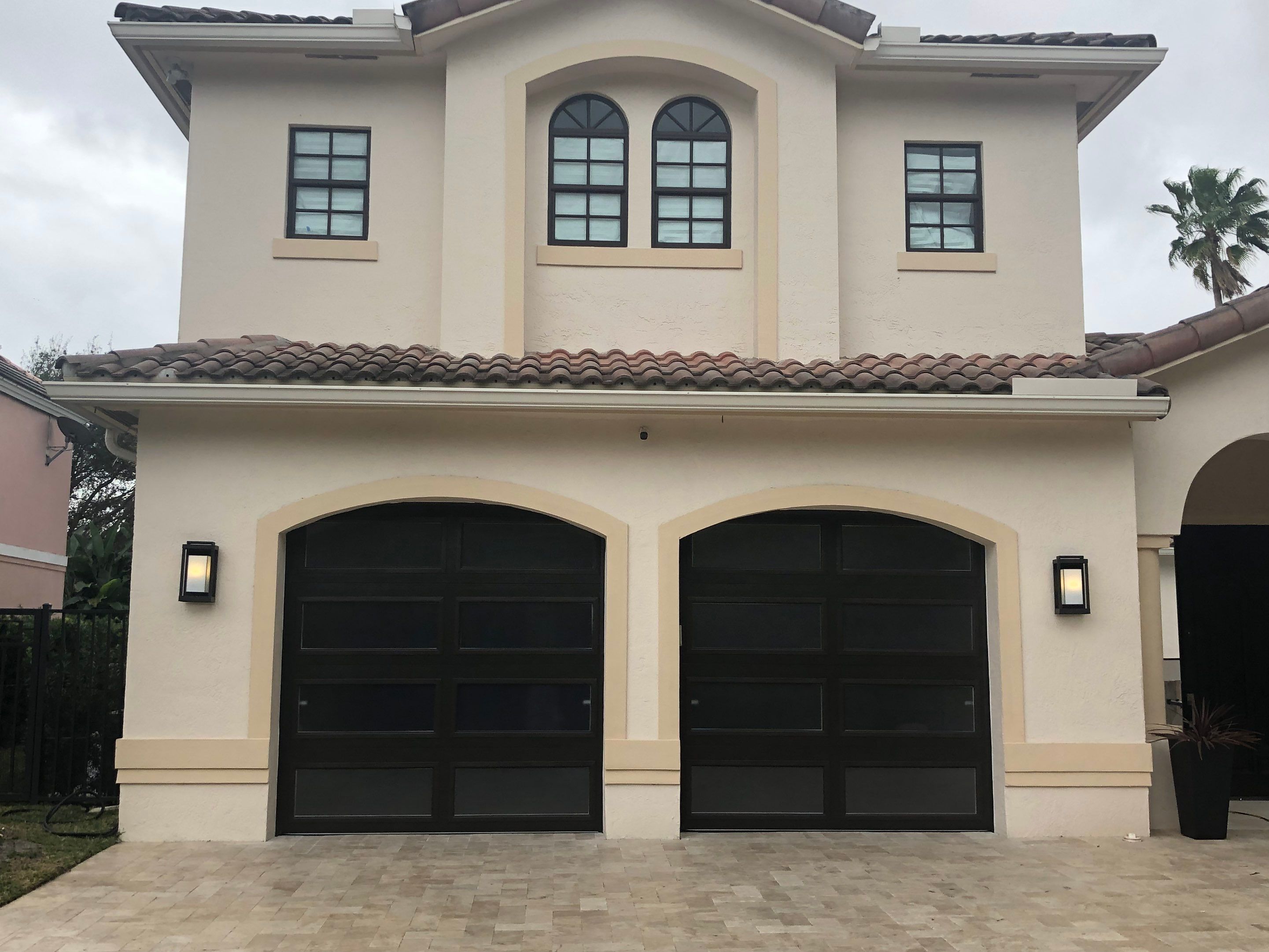 Modern Bronze Garage Door Installation With Frosted Glass in Boca Raton by The Door Doctor of South Florida, Inc.