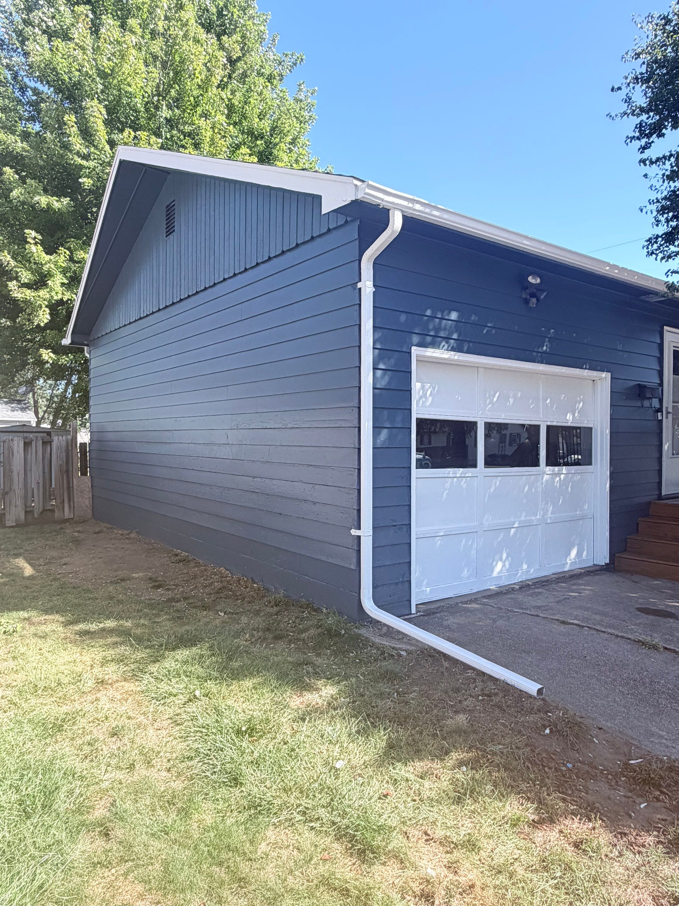 Dark Blue Exterior Painting and Trim Refresh in Sioux Falls by Select Painting, Coatings & Garage Cabinets