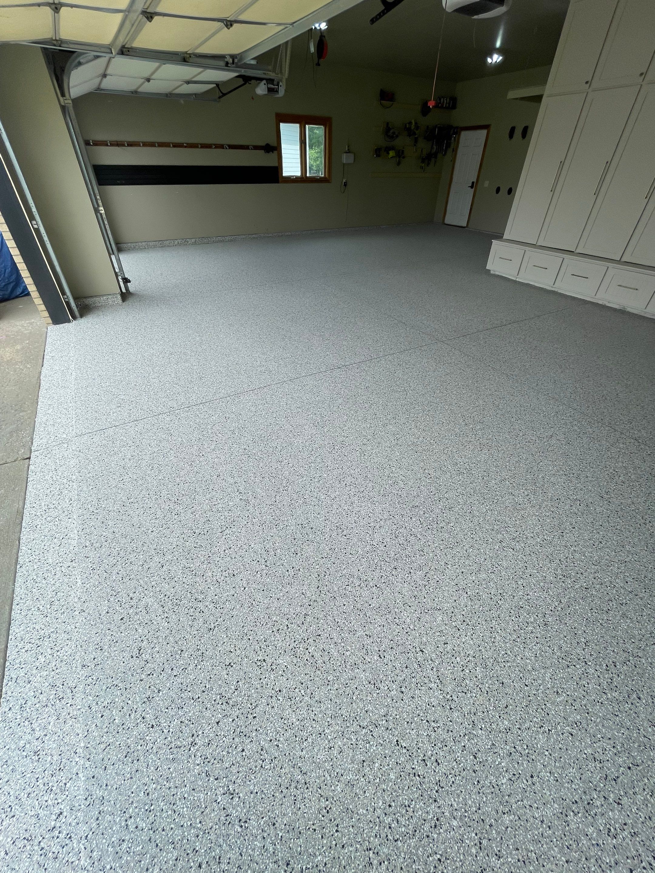 Cabin FEver Flake Garage Floor Coating Installation in Sioux Falls by Select Painting, Coatings & Garage Cabinets