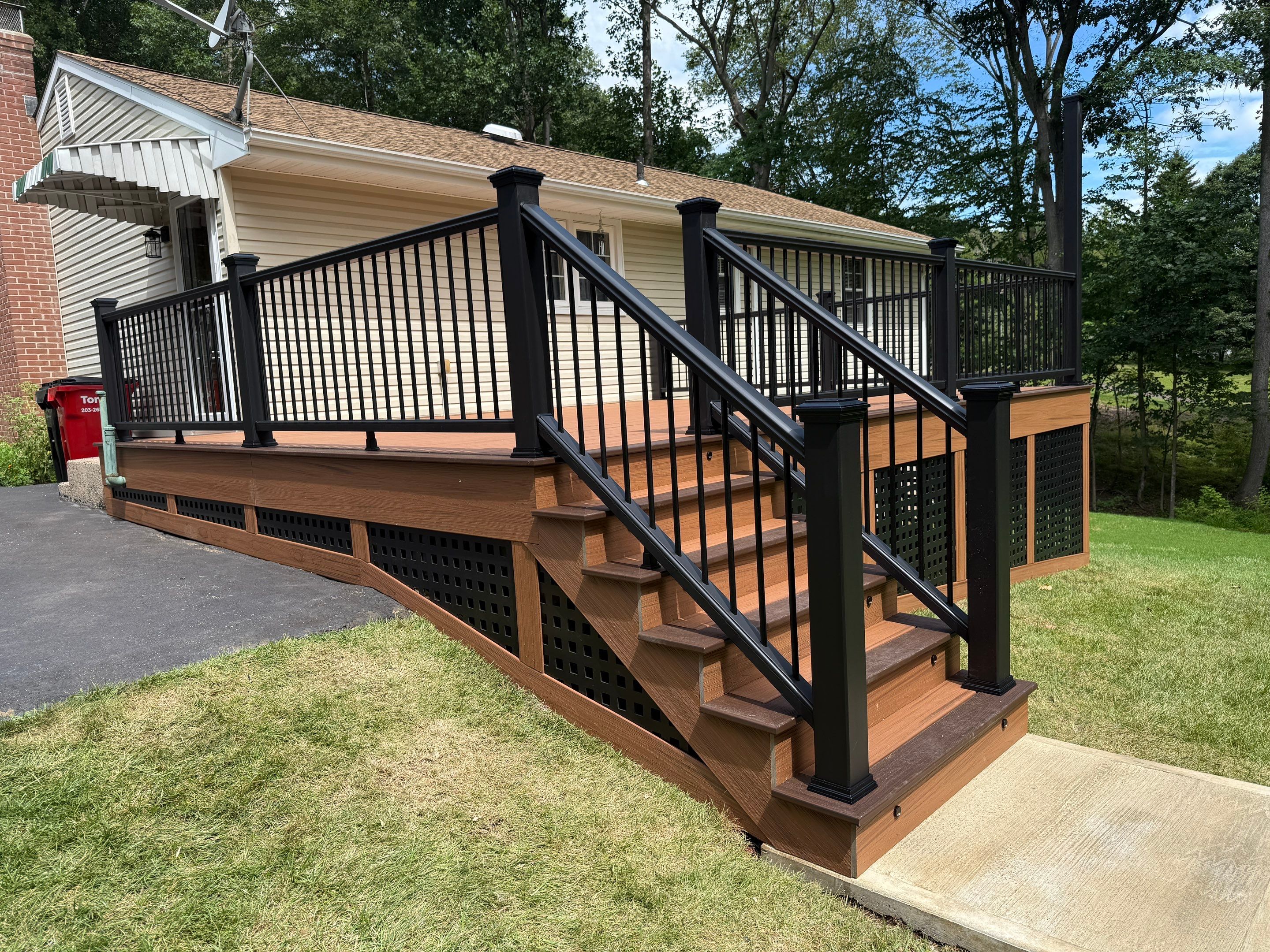 Replacement Deck, Trex Tropical Tiki torch , Matching Fascia. Black Transcend railing and Lattice. by DiGiorgi Roofing and Siding Inc