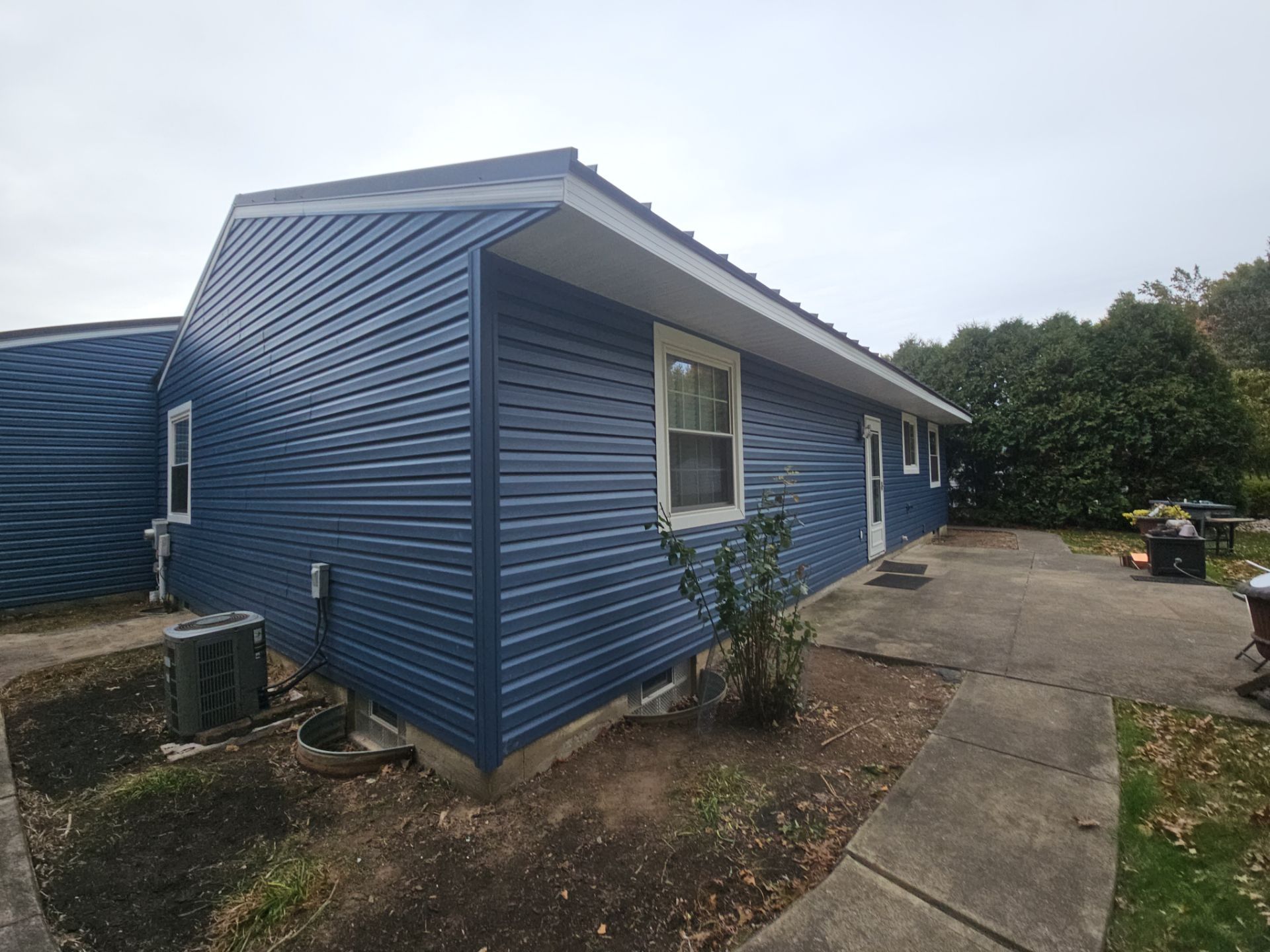 Wadsworth Exterior Transformation Featuring Blue Vertical Siding and Metal Roofing by Cornerstone Roofing And Siding