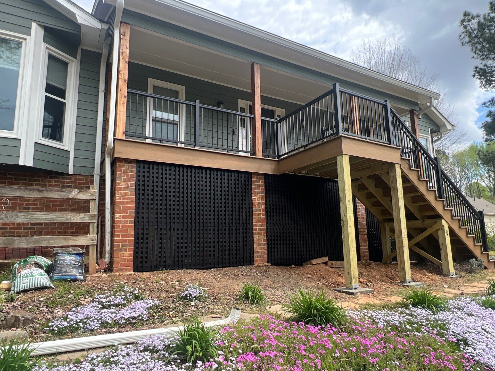 Composite Deck and Porch Renovation With Black Metal Railings by Swift Home Renovations 