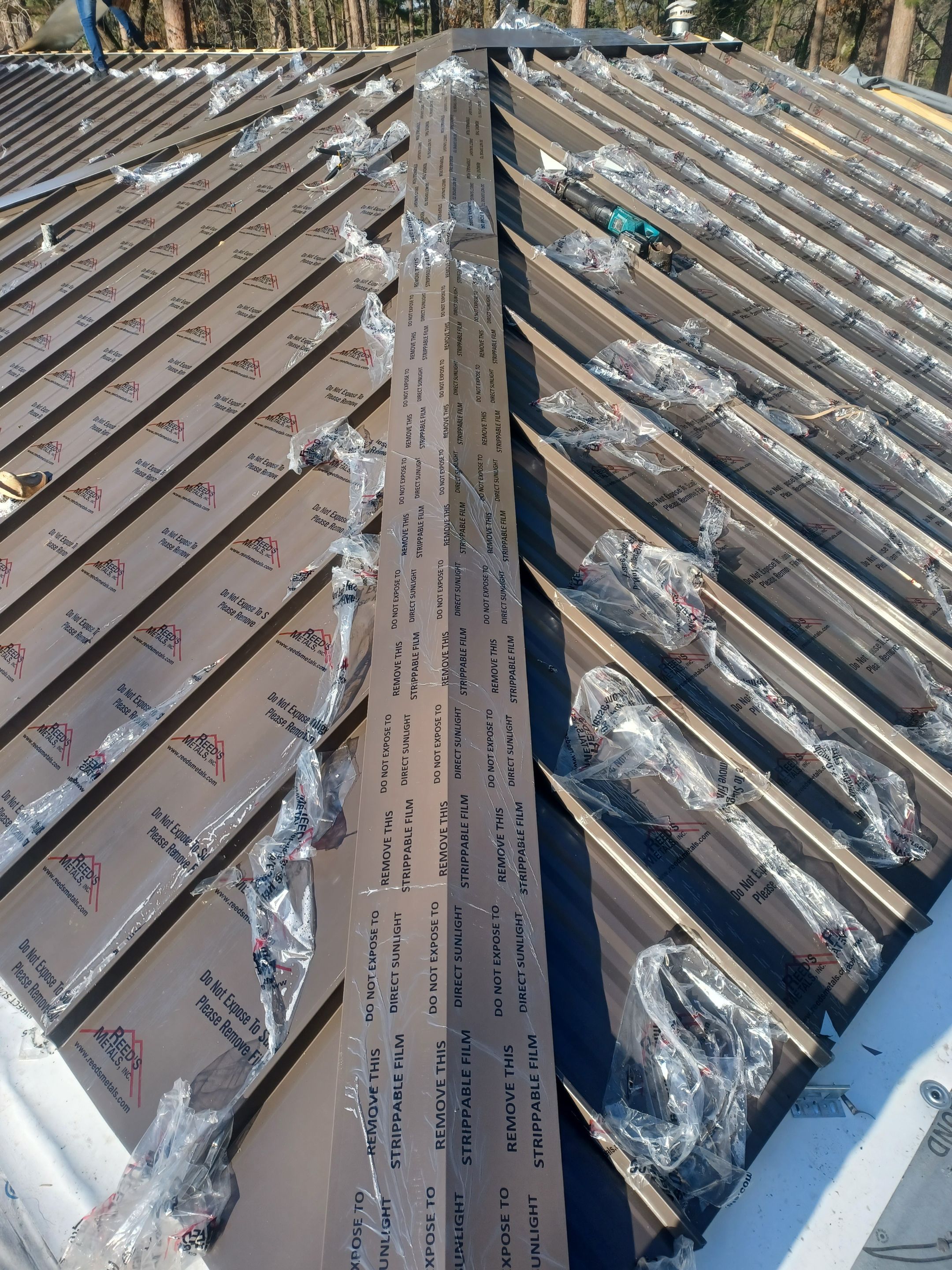 Residential Roofing Installation using PVC membrane and 24 gauge Standing Seam Metal by Hostetler Roofing